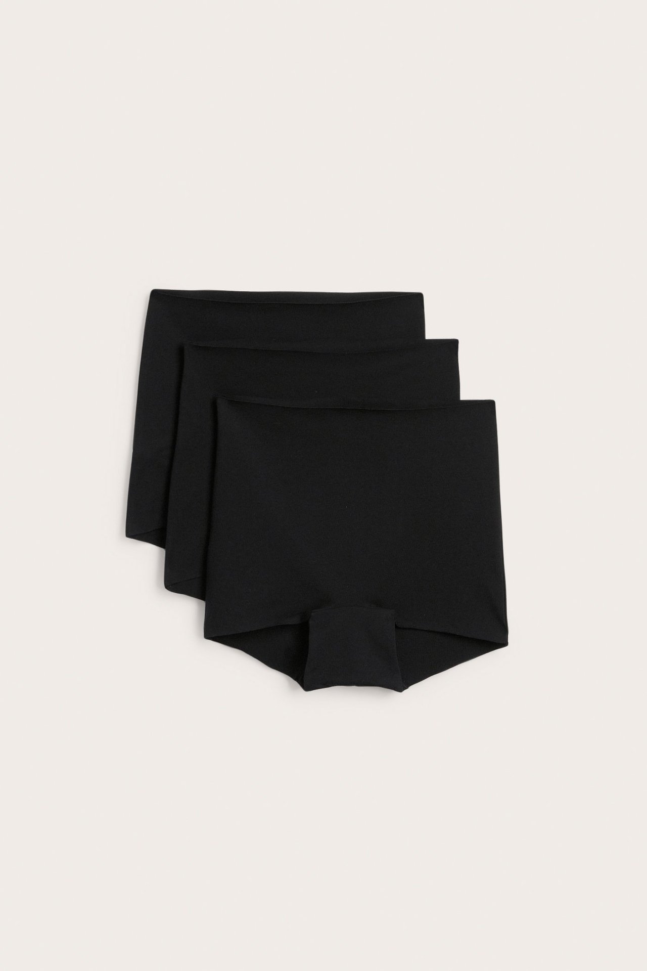 Platt vy av ett 3-pack svarta, sömlösa boxertrosor i mjuk bomullsblandning.