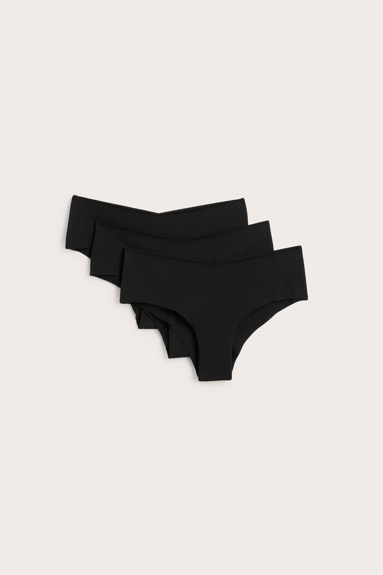 Ovanifrån: Ett 3-pack svarta sömlösa mammatrosor med låg midja i mjuk bomullsblandning.