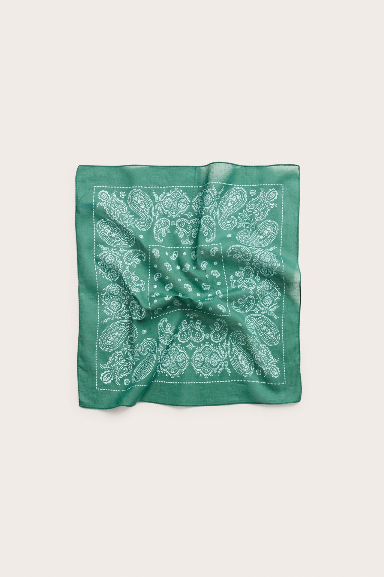 Edestä, vihreä neliömäinen puuvillahuivi valkoisella paisleykuviolla.