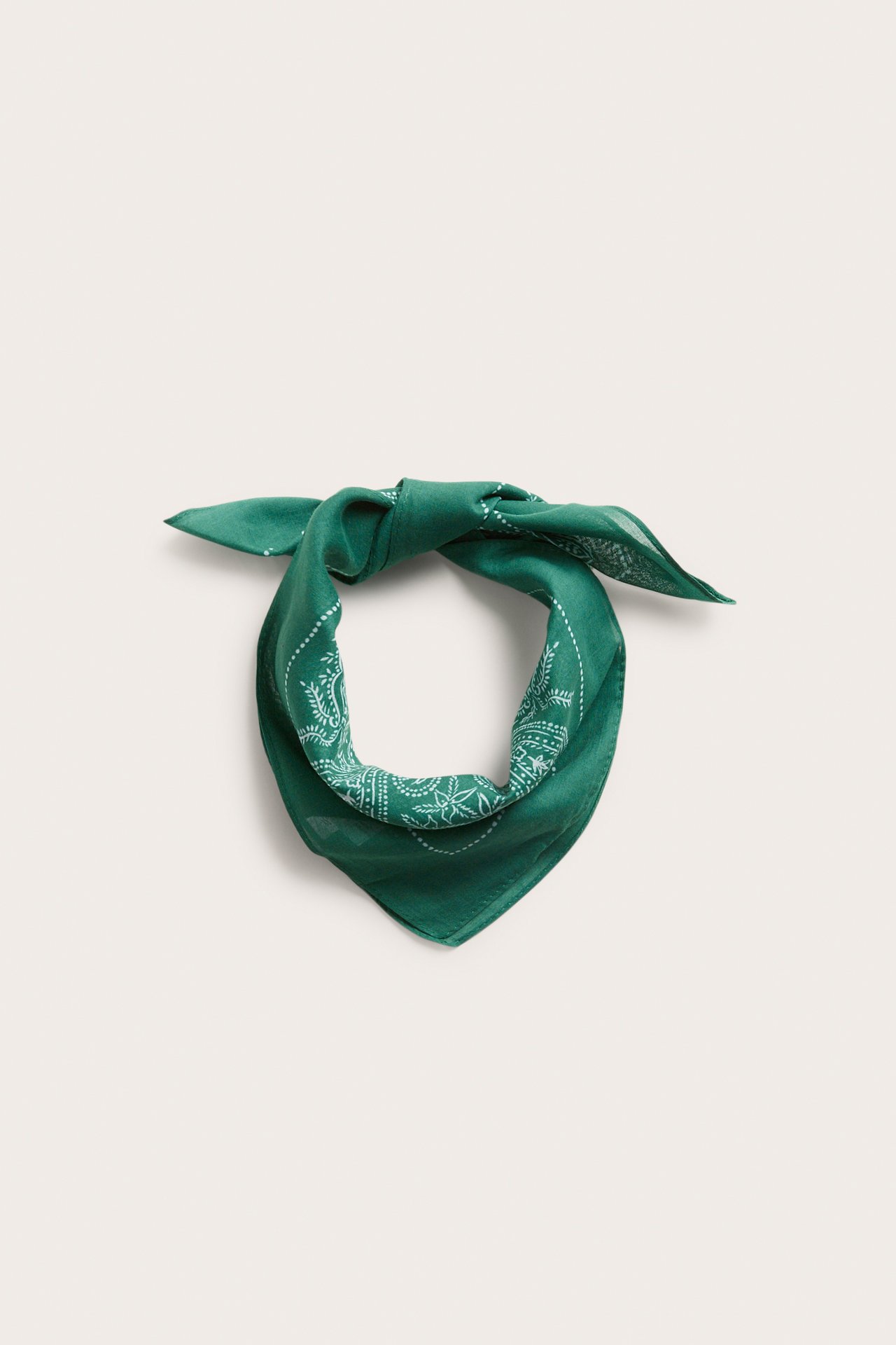 Widok z przodu zielonego, wzorzystego, cienkiego bawełnianego szalika, zawiązanego w węzeł.