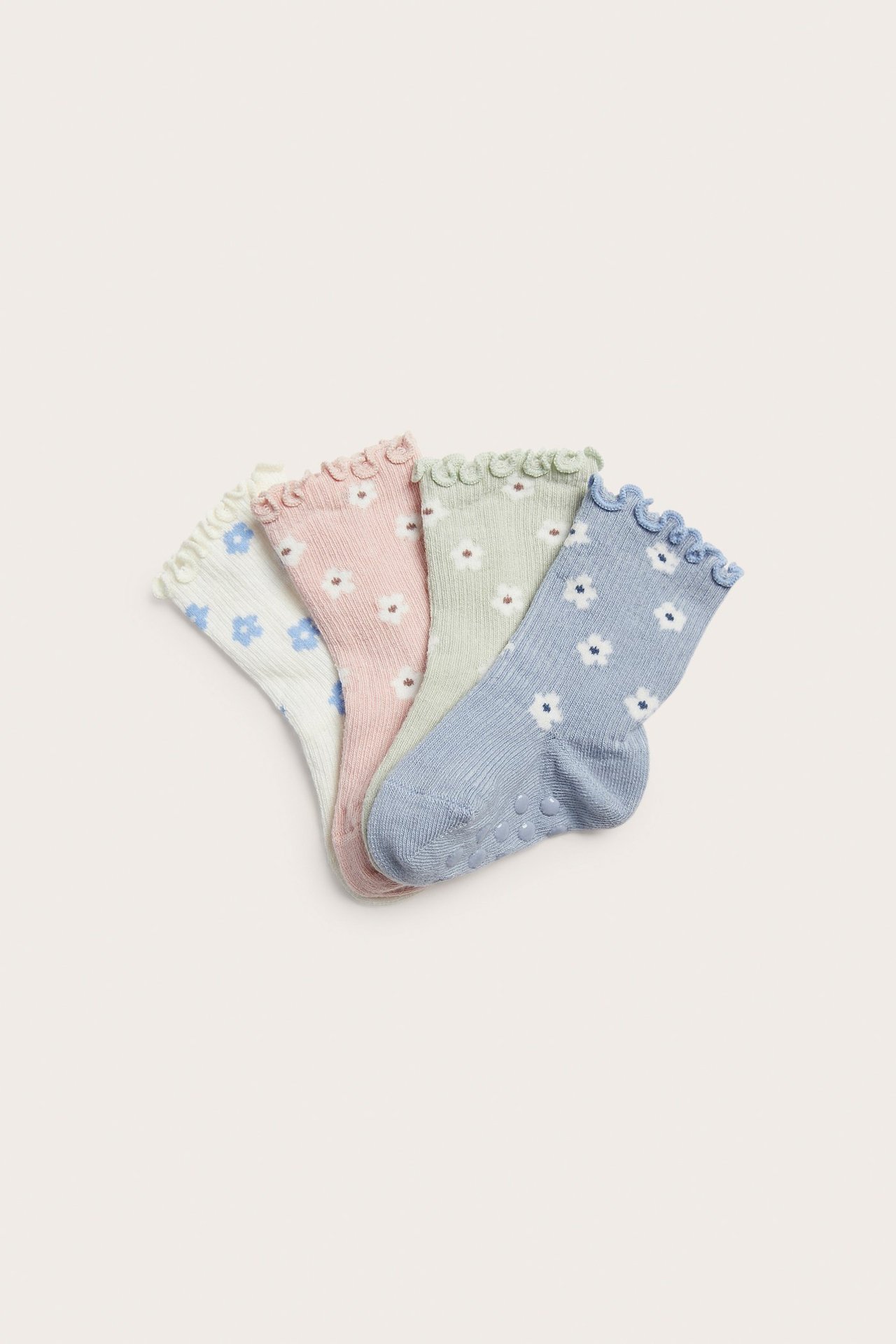 Cztery skarpetki niemowlęce: jasnoniebieskie, różowe, zielone, białe, z kwiatami, antypoślizgowe.