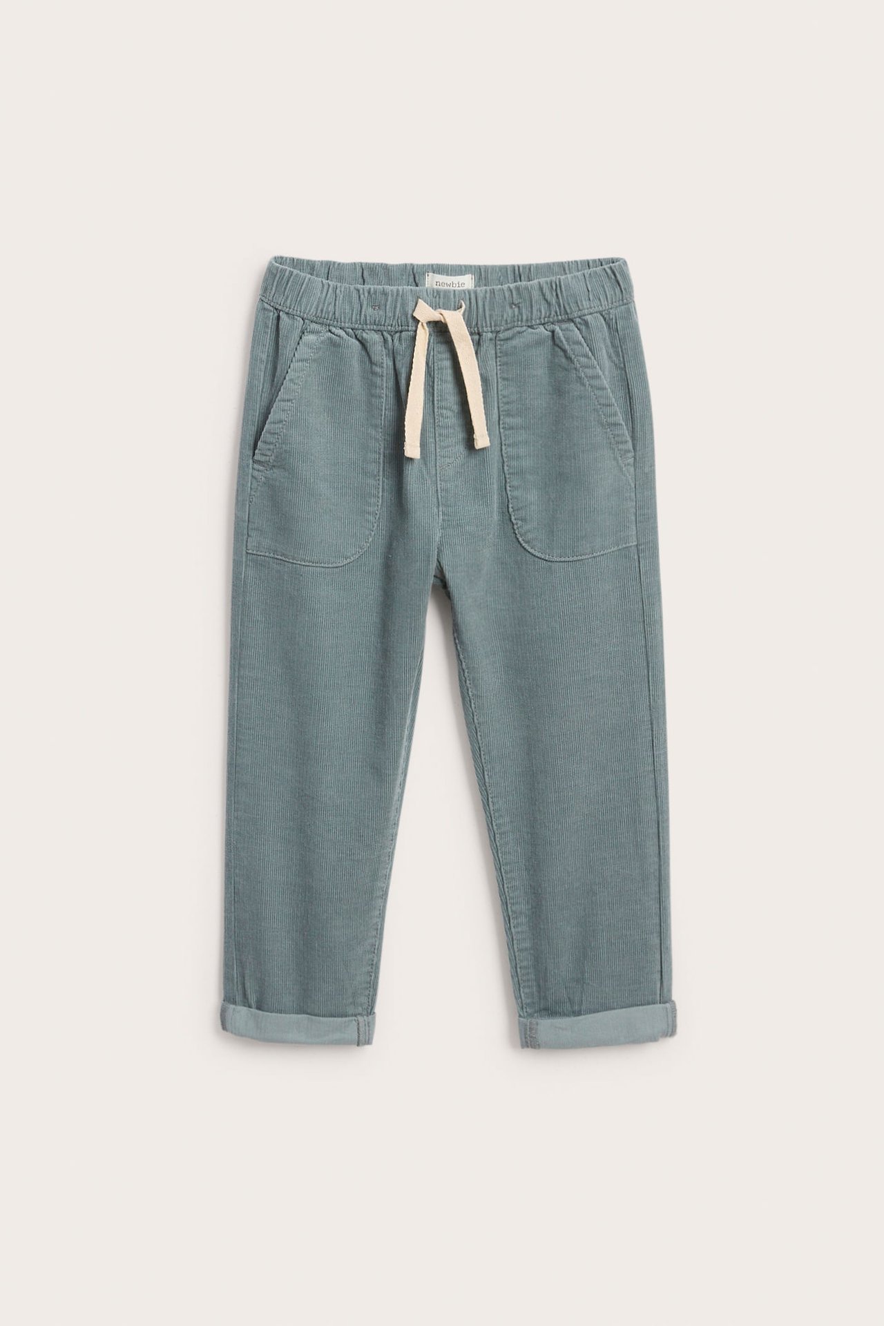 Edestä, lasten pölynsiniset vakosamettihousut joustovyötäröllä ja kermanvärisellä kiristysnyörillä.
