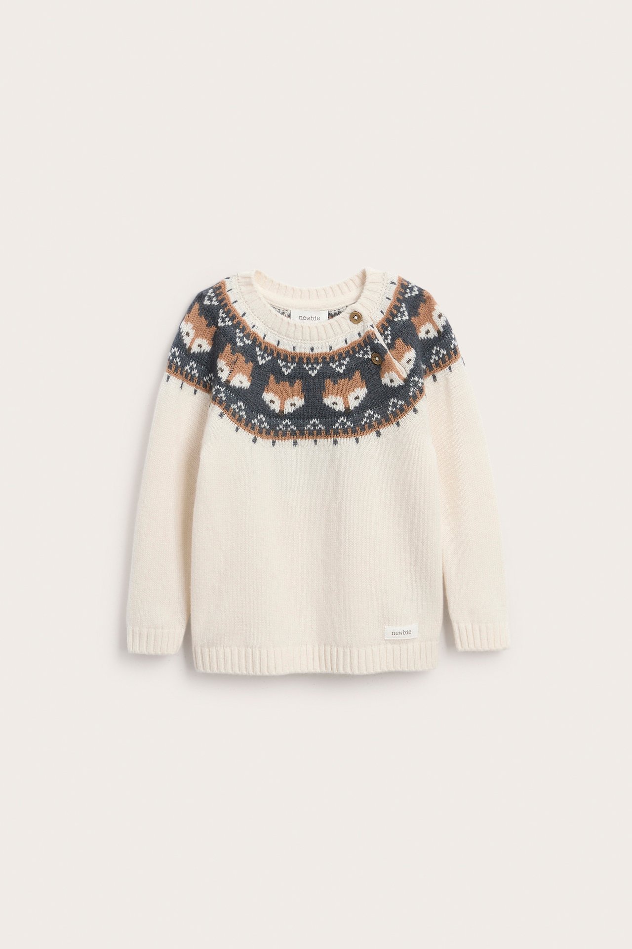 Widok z przodu, sweter niemowlęcy ecru z norweskim wzorem w brązowe i szare lisy, guziki na ramieniu.