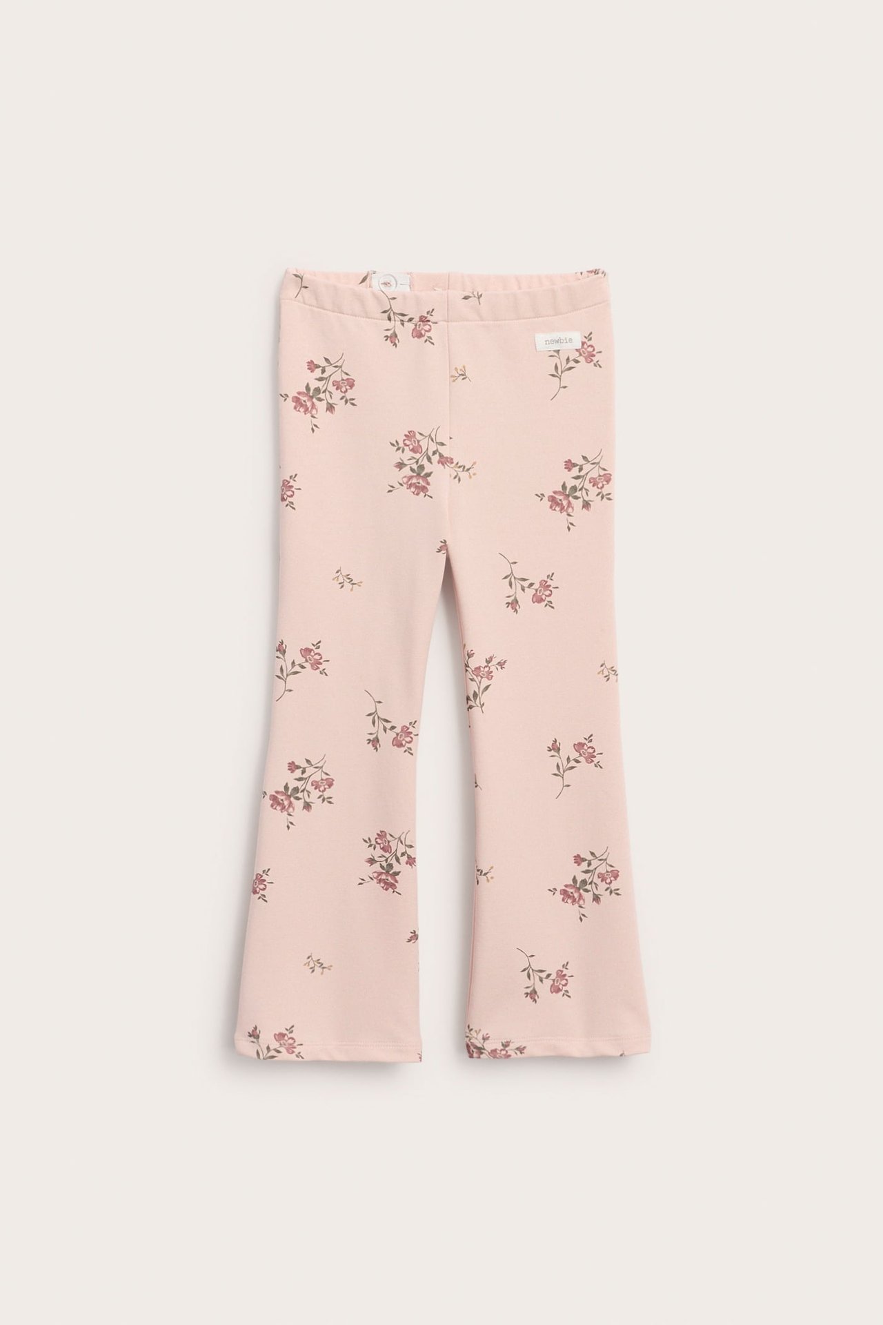 Lys rosa utsvingt jerseybukse med blomstermønster og elastisk midje, forfra.