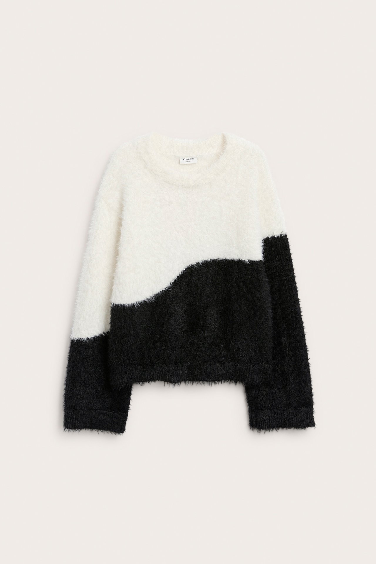 Framifrån, en fluffig, långärmad tröja med rund hals, i vitt och svart vågigt färgblock.