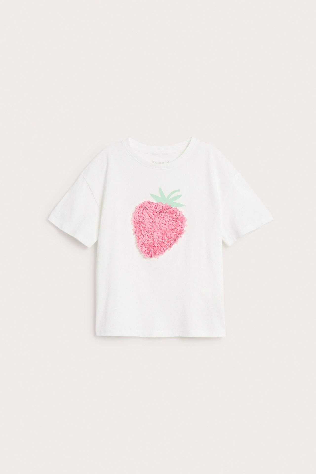 Framsida av offwhite barn-t-shirt i bomull med rosa jordgubbsapplikation i mesh framtill.