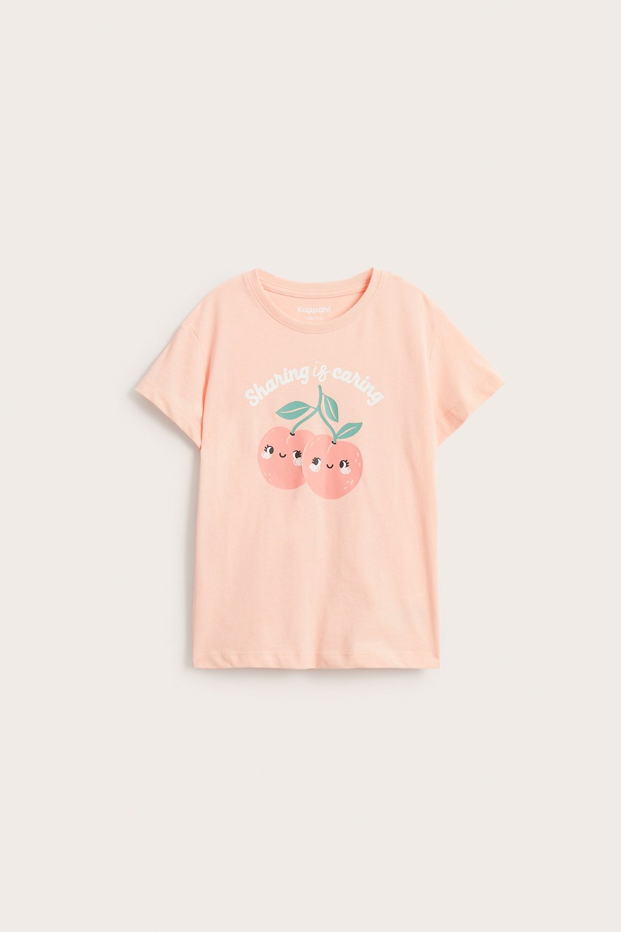 Framifrån: en ljus korallfärgad t-shirt i bomull för barn med persikoprint och texten "Sharing is caring".