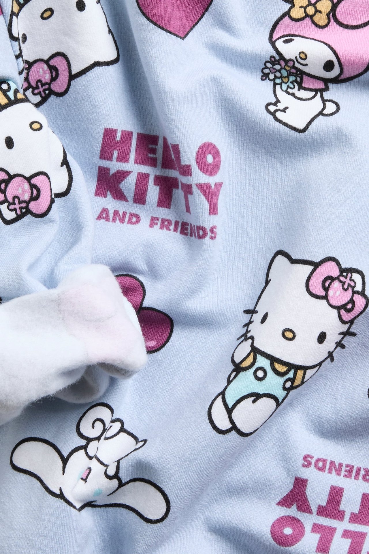 Zbliżenie na jasnoniebieski materiał z nadrukiem Hello Kitty and Friends.