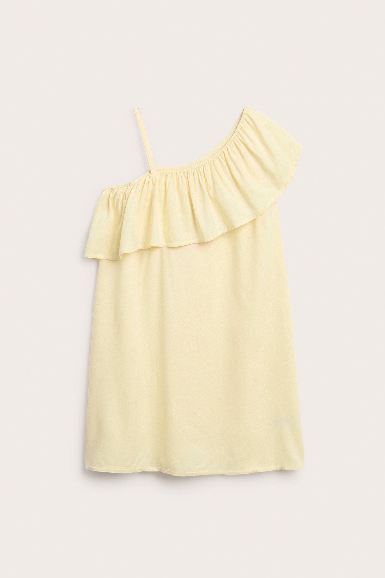 Edestä, vaaleankeltainen lasten one shoulder mekko röyhelöreunalla ja säädettävällä hihnalla.