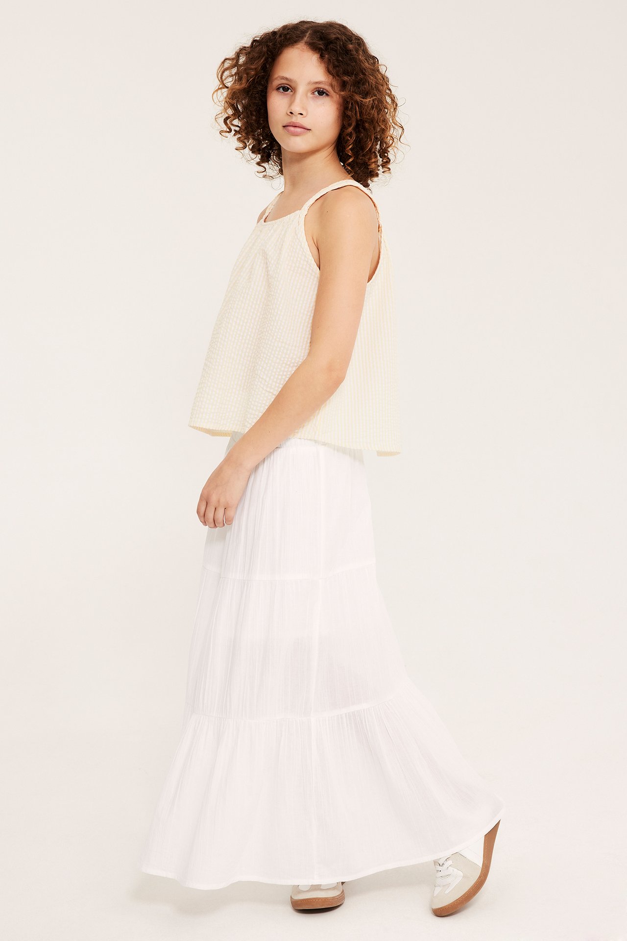 Dziewczynka: Żółta prążkowana bawełniana bluzka bez rękawów, plecione ramiączka, i biała spódnica maxi.