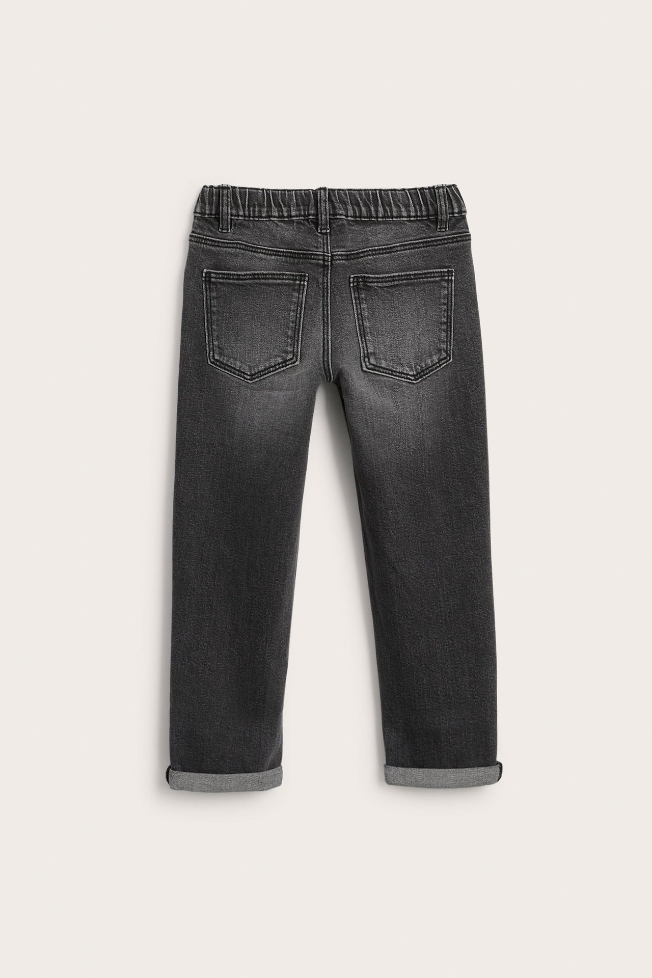 Bakifrån av mörkgrå barnjeans med elastisk midja och uppvikta benslut.