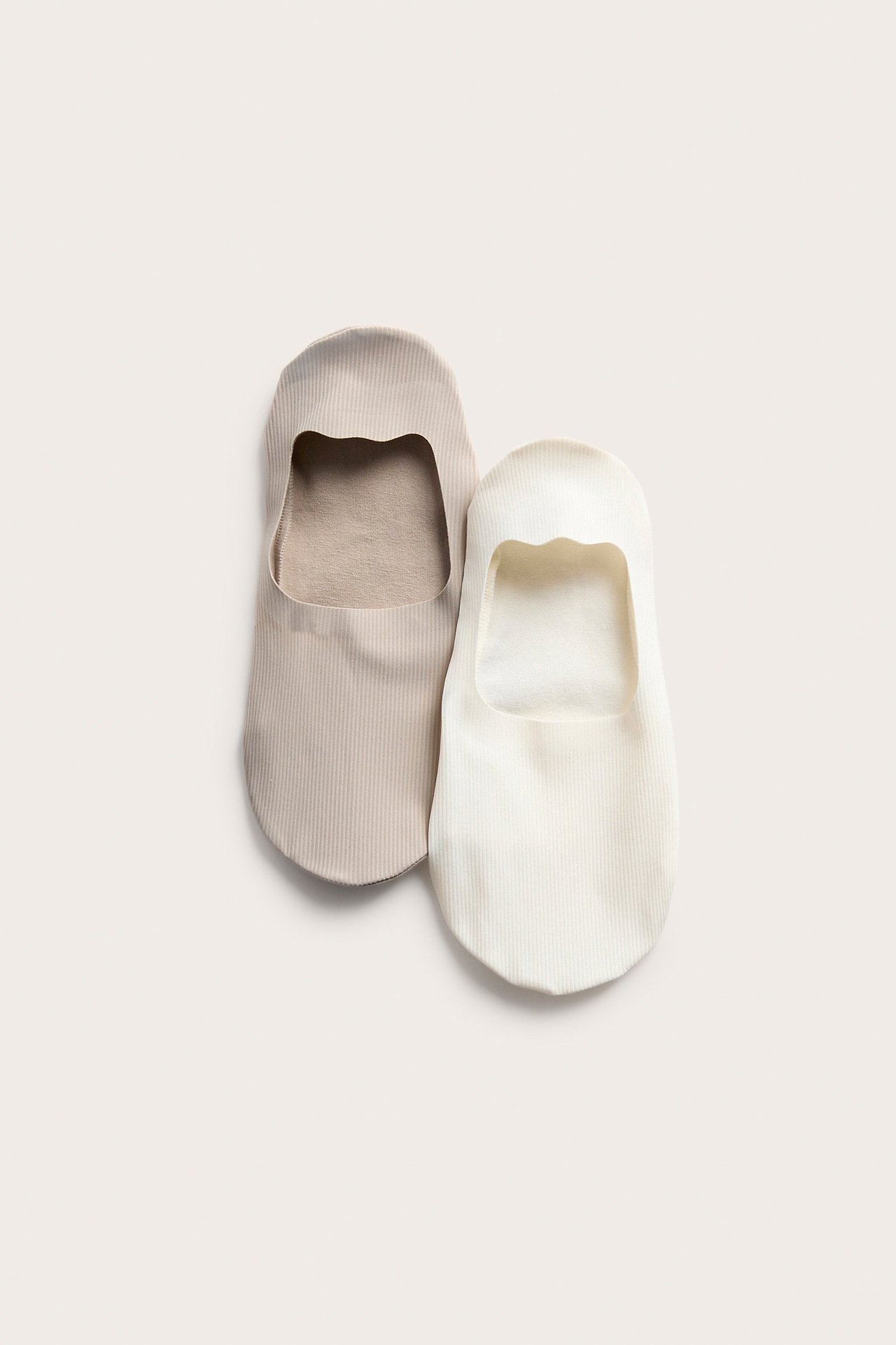 Yleiskuva kahdesta ribatusta, matalasta huomaamattomasta sukasta, väreissä luonnonvalkoinen ja vaalea beige.