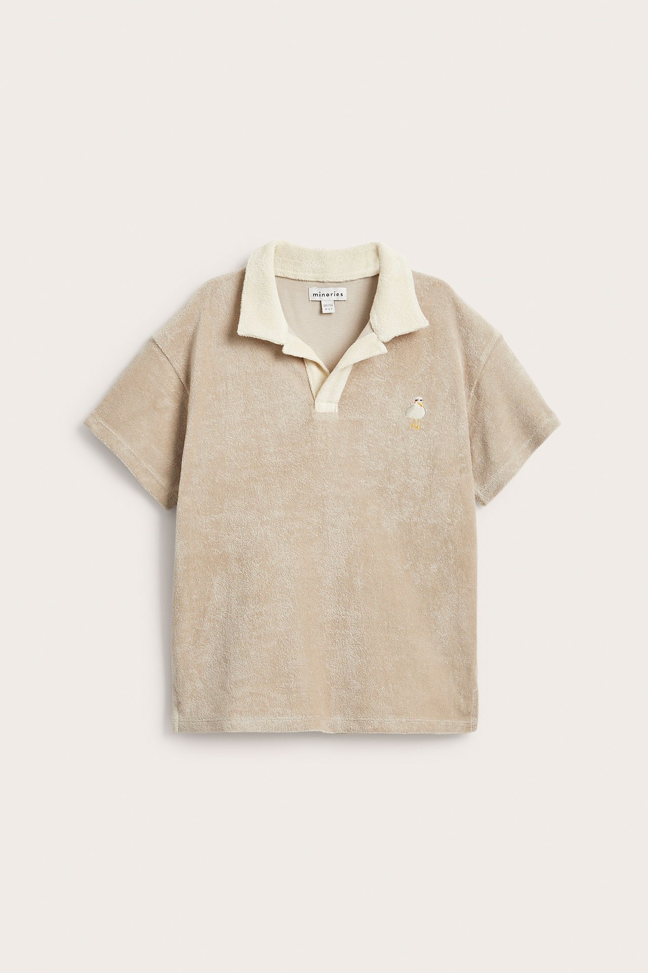 Framifrån, beige kortärmad frottétröja med cremevit krage och fågelbrodyr.