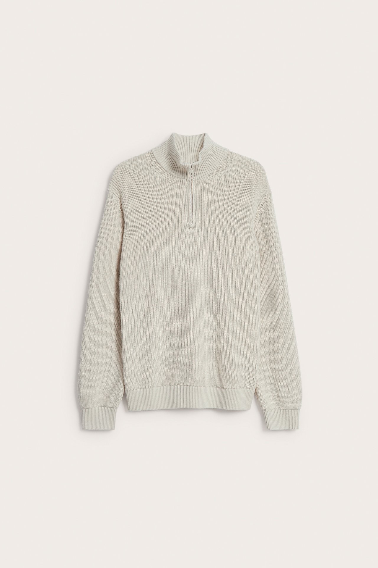 Framifrån av en ljusbeige ribbad halvzip-tröja.