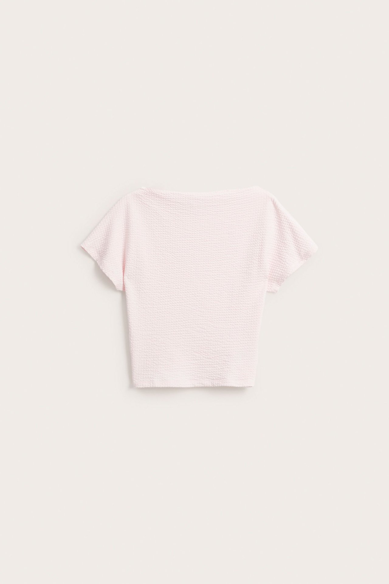 Edestäpäin: Vaaleanpunainen pucker-kangas lyhythihainen batwing-yläosa venekauluksella.