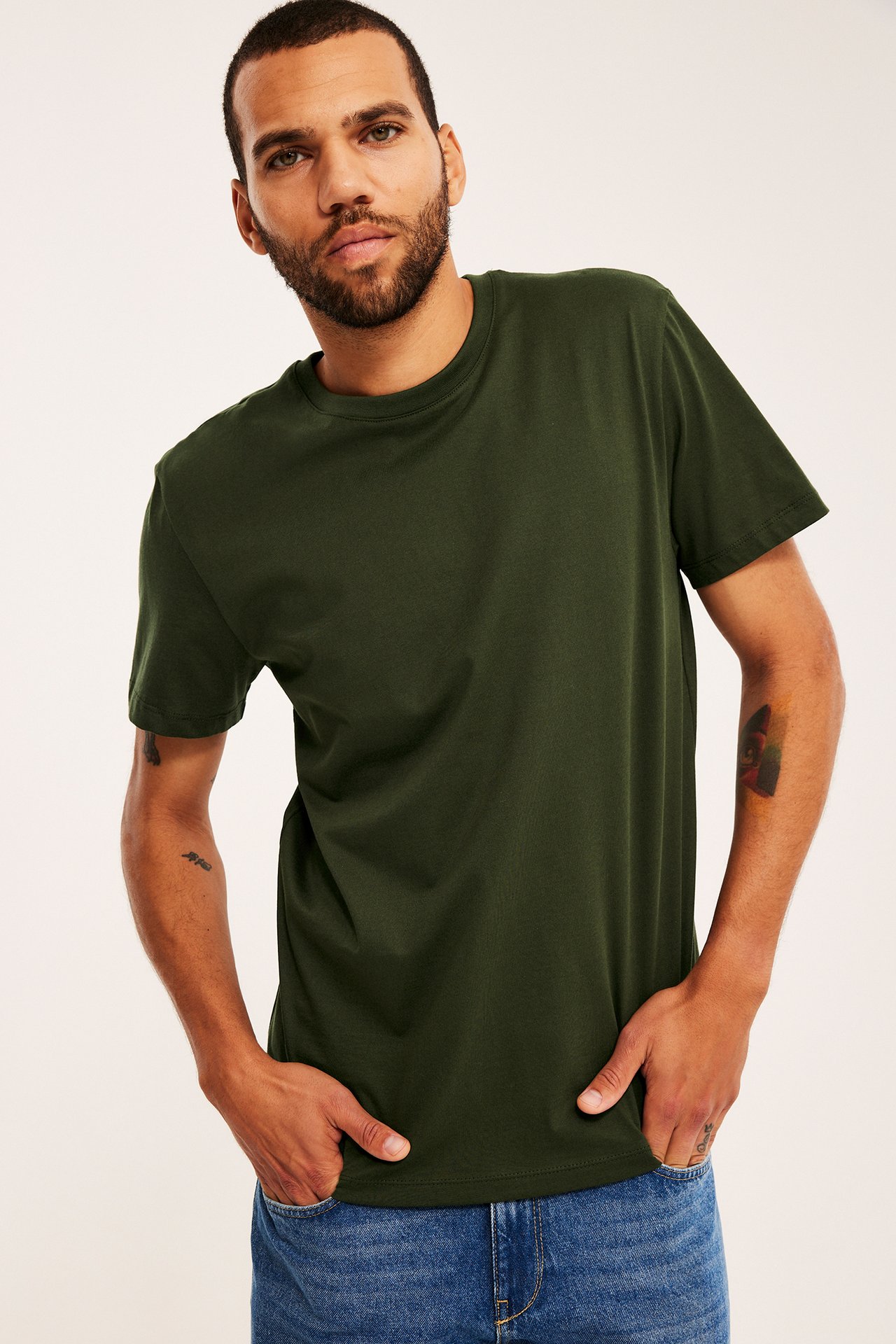 Herr mörkgrön kortärmad t-shirt, framifrån, med blå jeans.