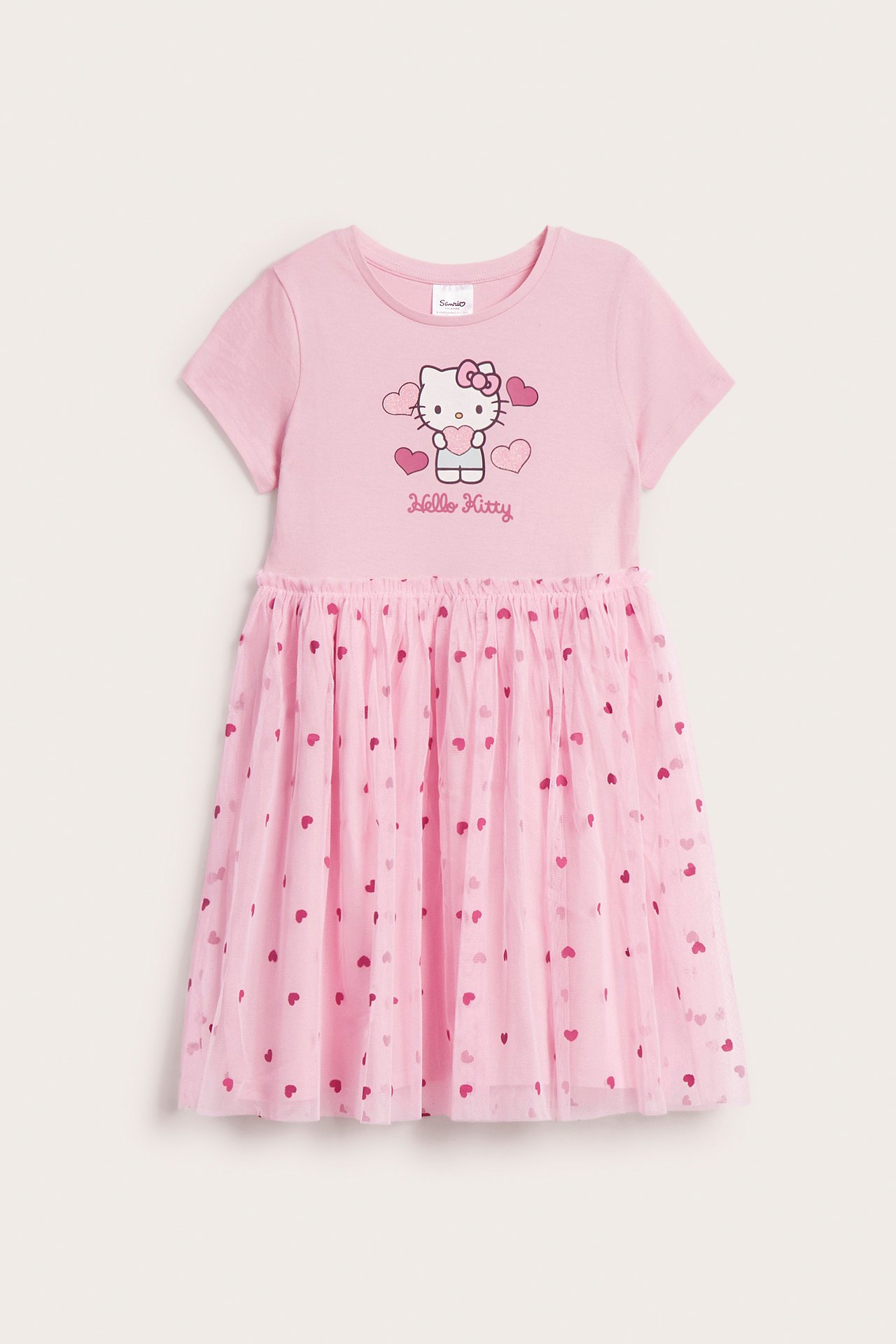 Frontvy: Rosa Hello Kitty kortärmad barnklänning med tyllkjol med hjärtmönster.