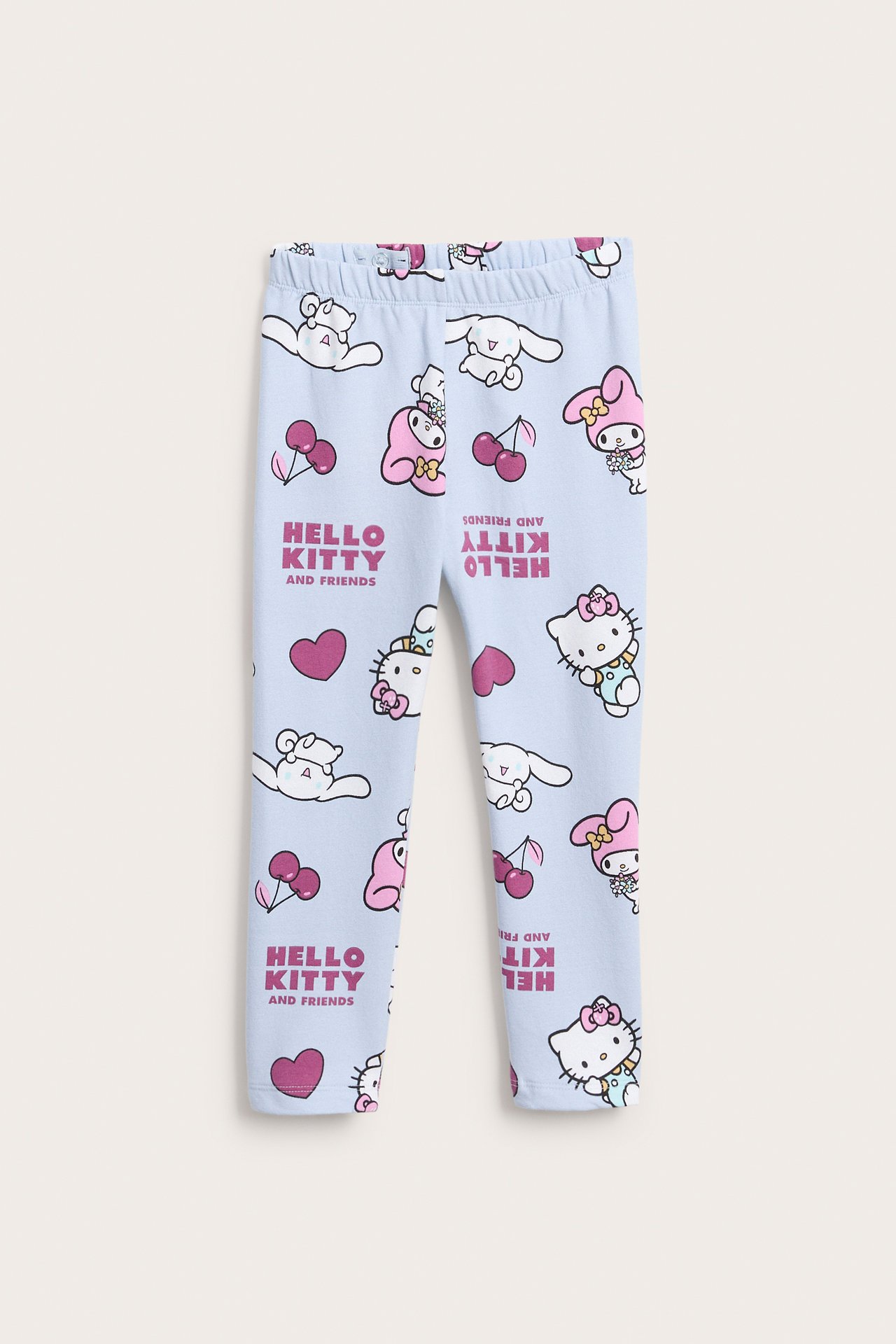 Widok z przodu jasnoniebieskich legginsów dziecięcych z nadrukiem Hello Kitty i przyjaciół.