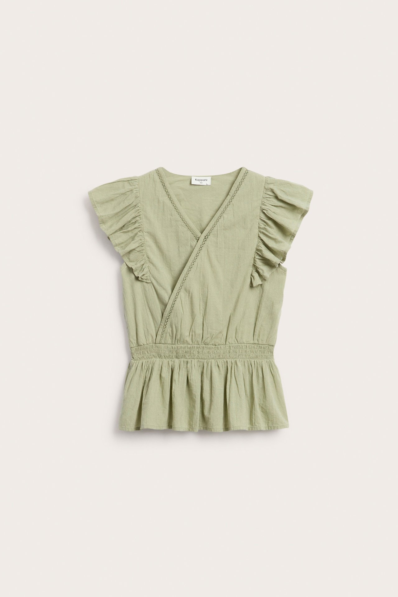 Edestä näkymä lasten vihreästä puuvillavolankipuserosta, jossa pitsiä ja rypytetty vyötärö.