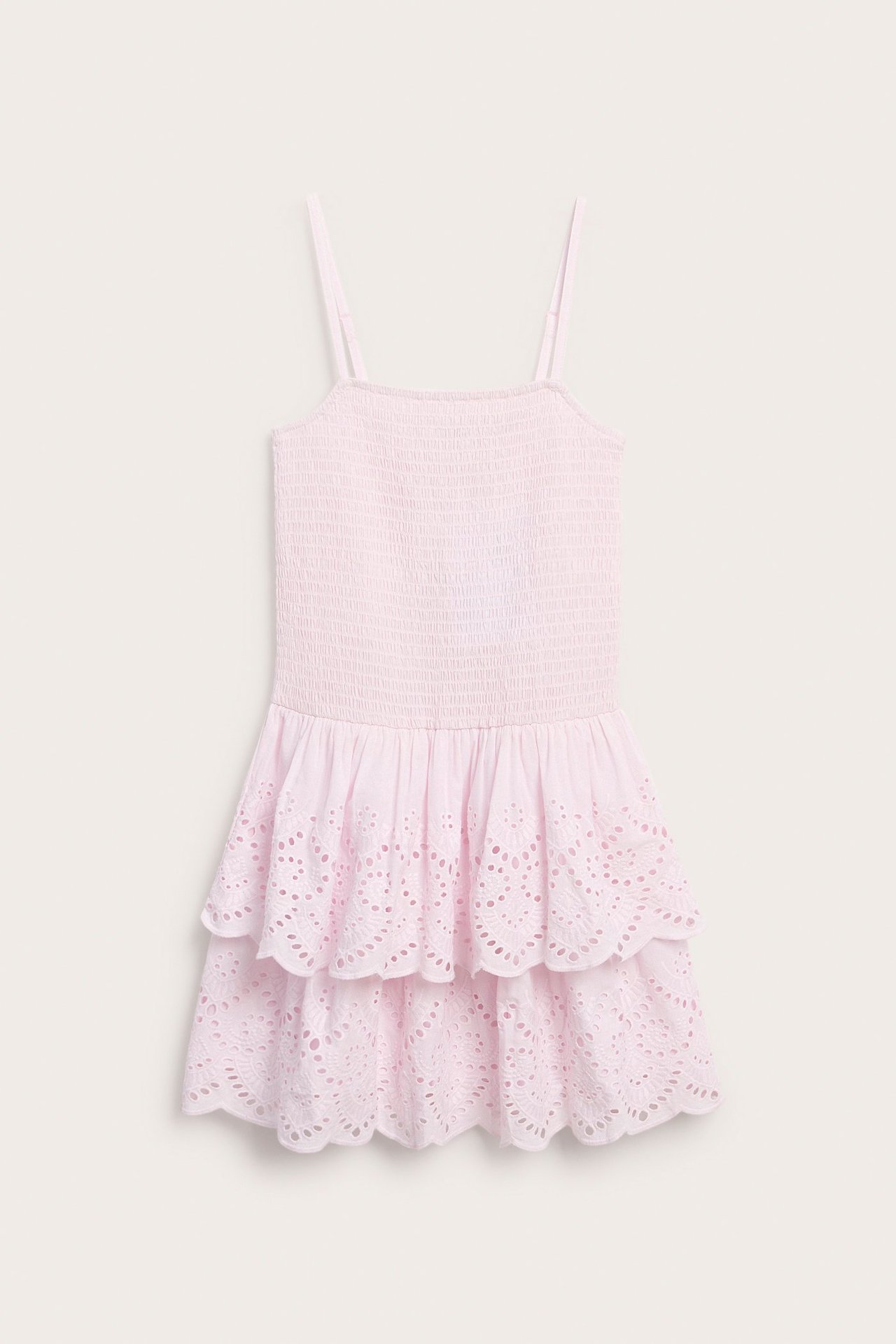 Edestä, vaaleanpunainen lasten puuvillamekko, smokkiosalla ja kerroksellisilla broderie anglaise -röyhelöillä.