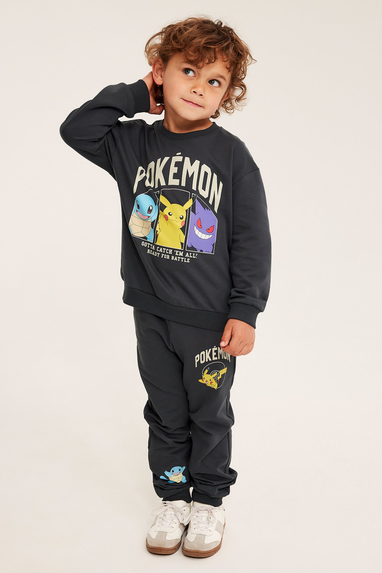 Frontvy av ett barn i mörkgrå Pokémon-sweatshirt och matchande mjukisbyxor i bomullsblandning.