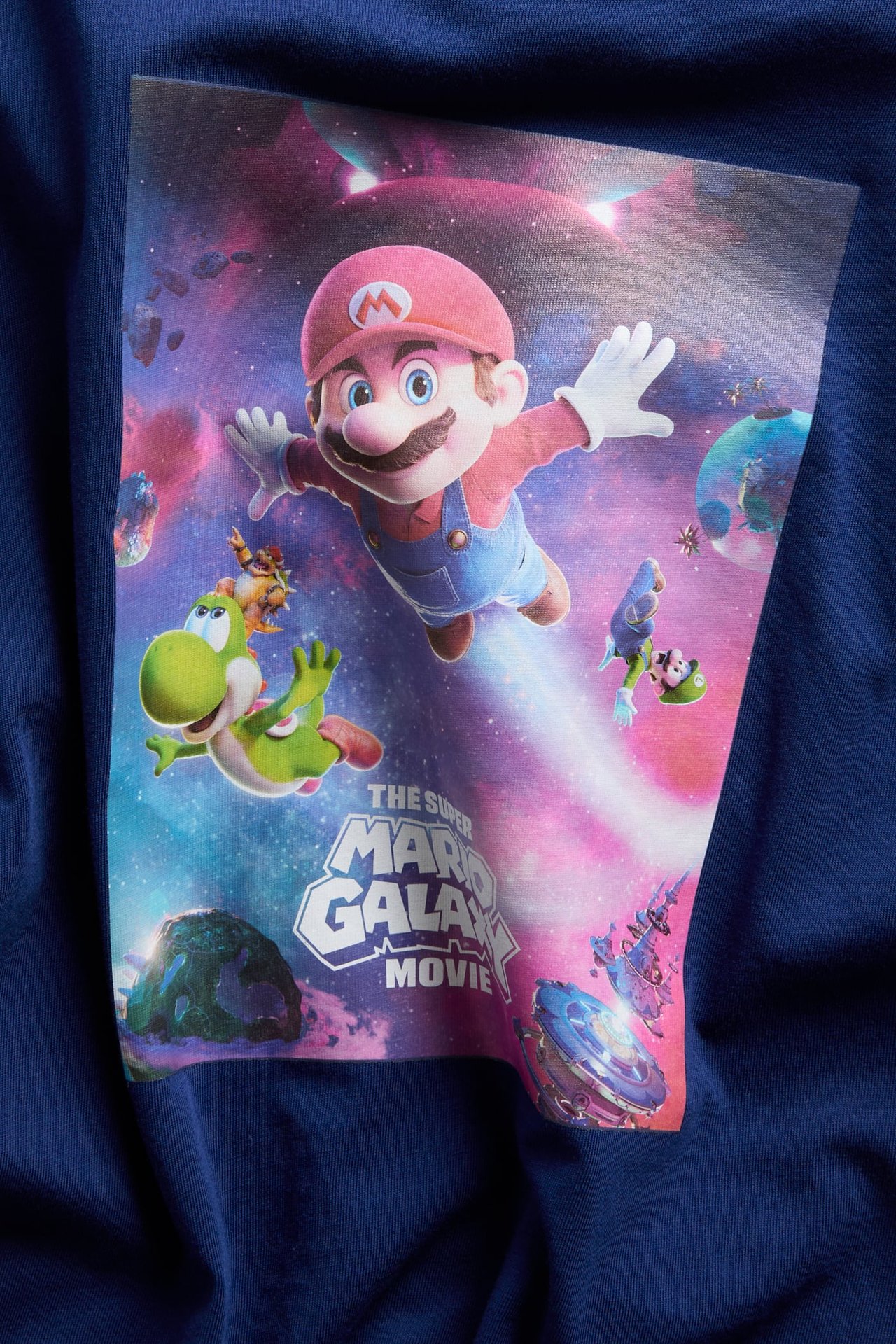 Zbliżenie: granatowy bawełniany T-shirt dla dziecka z dużym nadrukiem Super Mario Galaxy Movie z przodu.