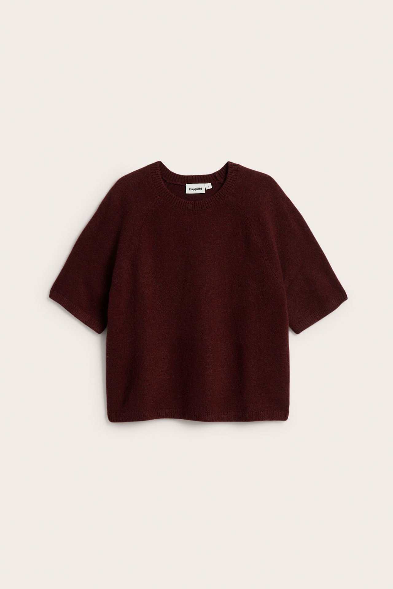 Frontvy av en oversized, melerad vinröd stickad t-shirt med korta ärmar och rund hals.