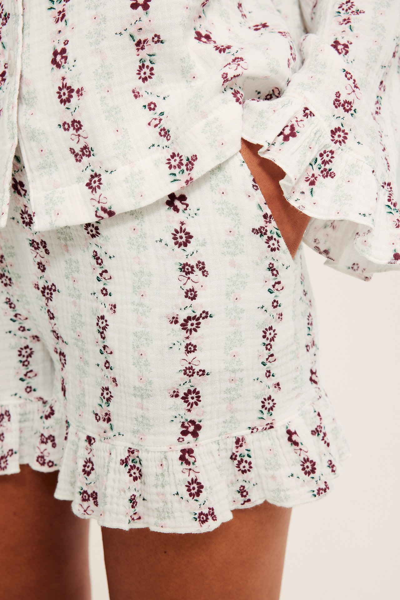 Närbild framifrån på vita texturerade mönstrade shorts med volanger, med matchande topp.