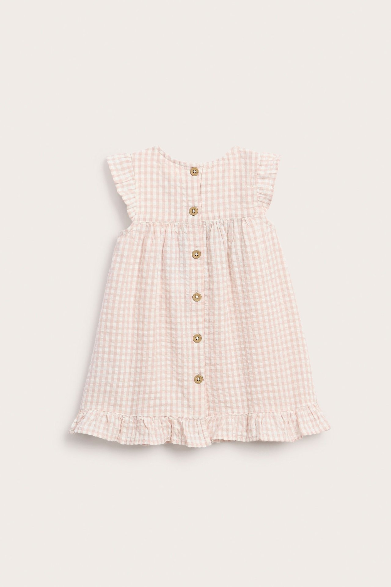 Jasnoróżowo-biała kraciasta bawełniana sukienka dziecięca z falbankami na rękawach, dole i guzikami z tyłu, widok z przodu.