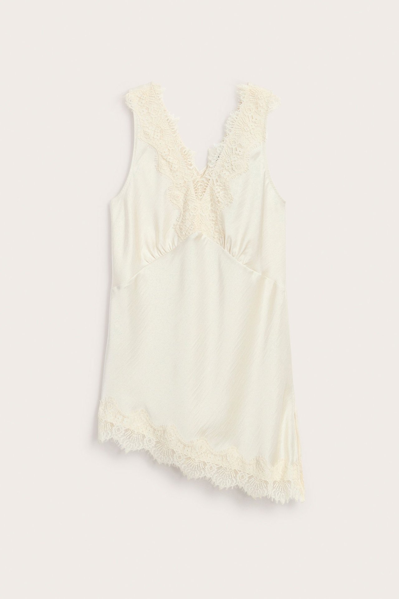 Framsida av offwhite satinlinne för dam med V-ringning, spetsdetaljer och asymmetrisk nederkant.