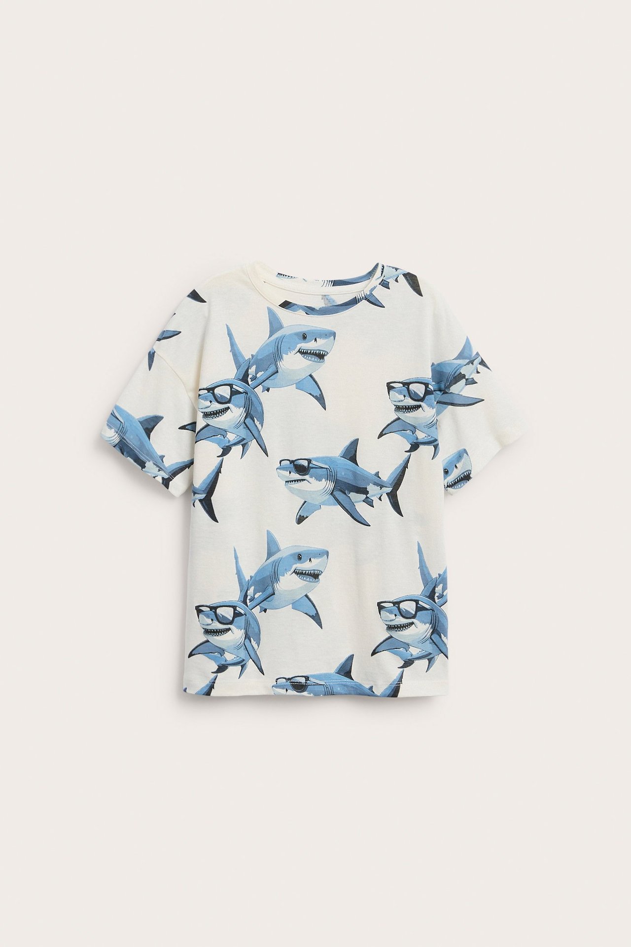 Widok z przodu: bawełniana koszulka dziecięca w kolorze ecru, o normalnym kroju, z nadrukiem rekinów.