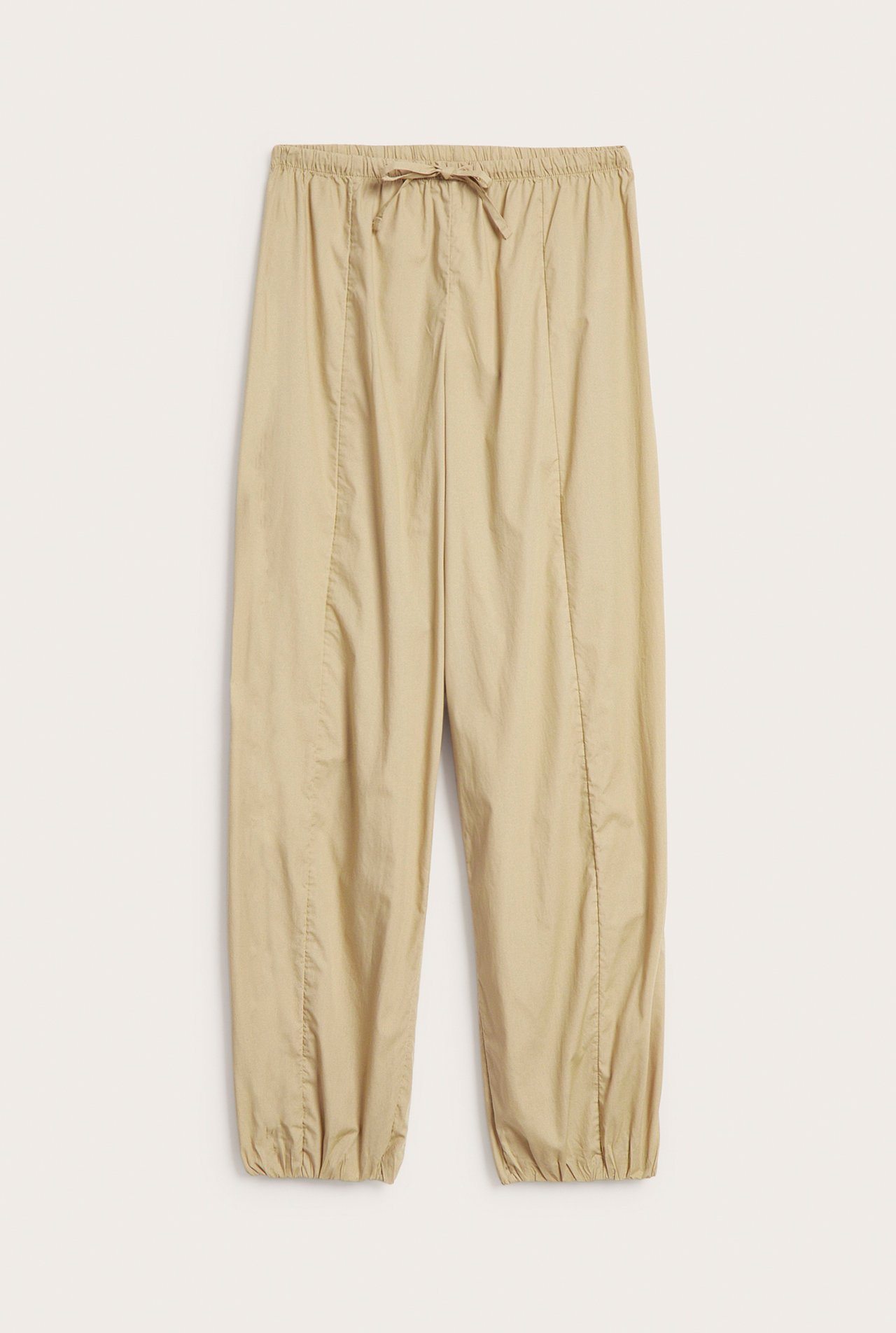 Edestä kuvatut beiget puuvillapopliinipallohousut, joissa joustovyötärö, kiristysnyöri ja joustavat lahkeensuut.