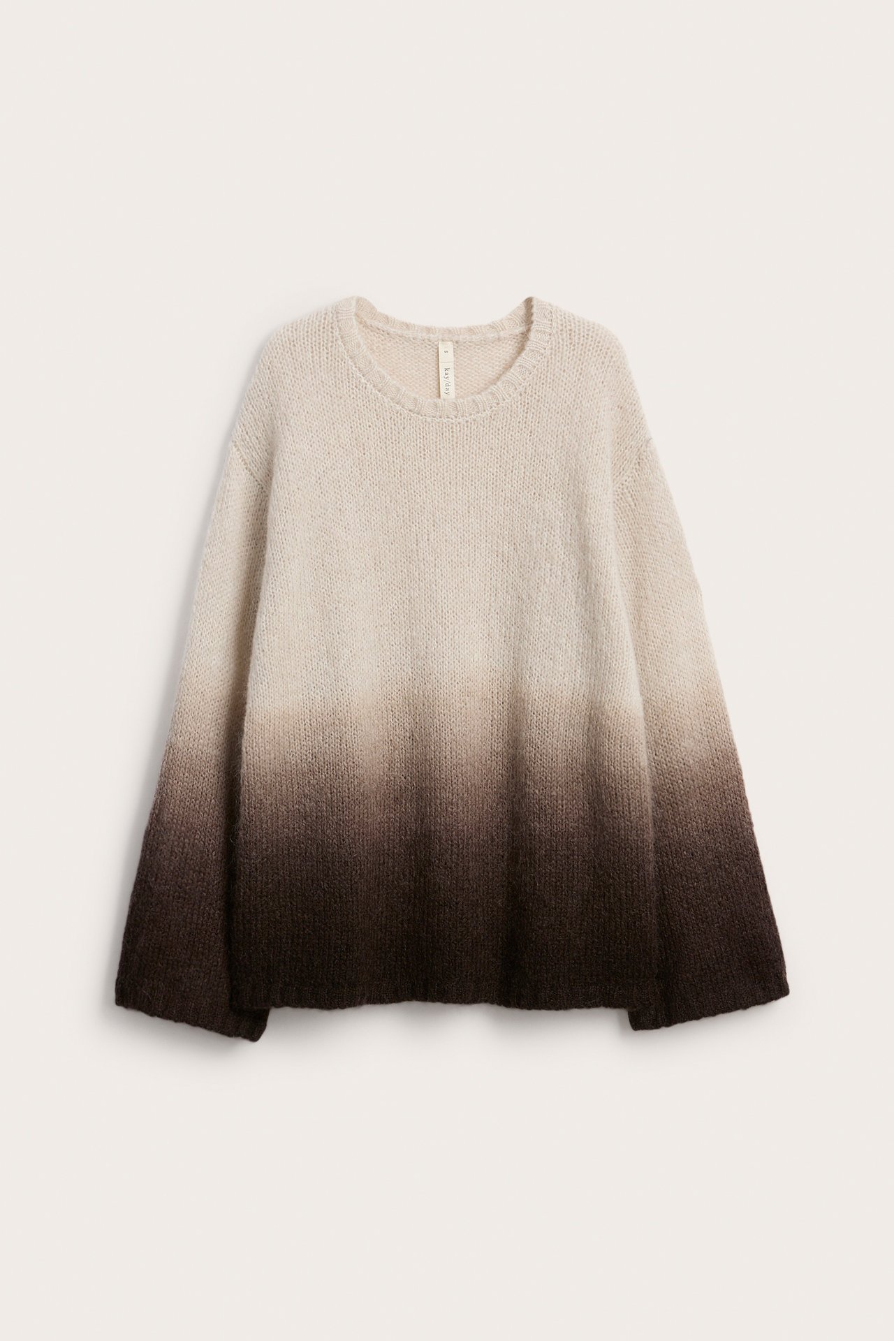 Edestäpäin kuvattu ylisuuri neulepusero, jossa pyöreä kaula-aukko ja ombré beige-ruskea liukuvärjäys.