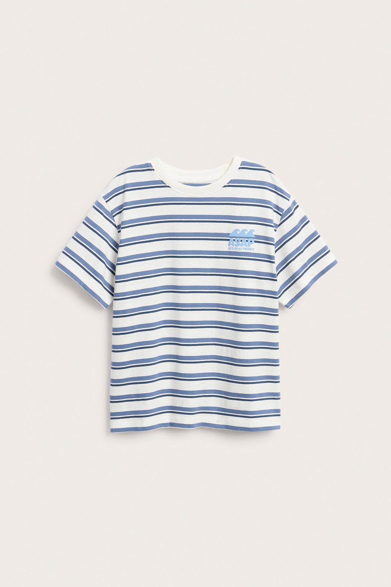 Edestäpäin kuvattu lasten oversize valko-siniraitainen puuvillainen t-paita rintakirjonnalla.