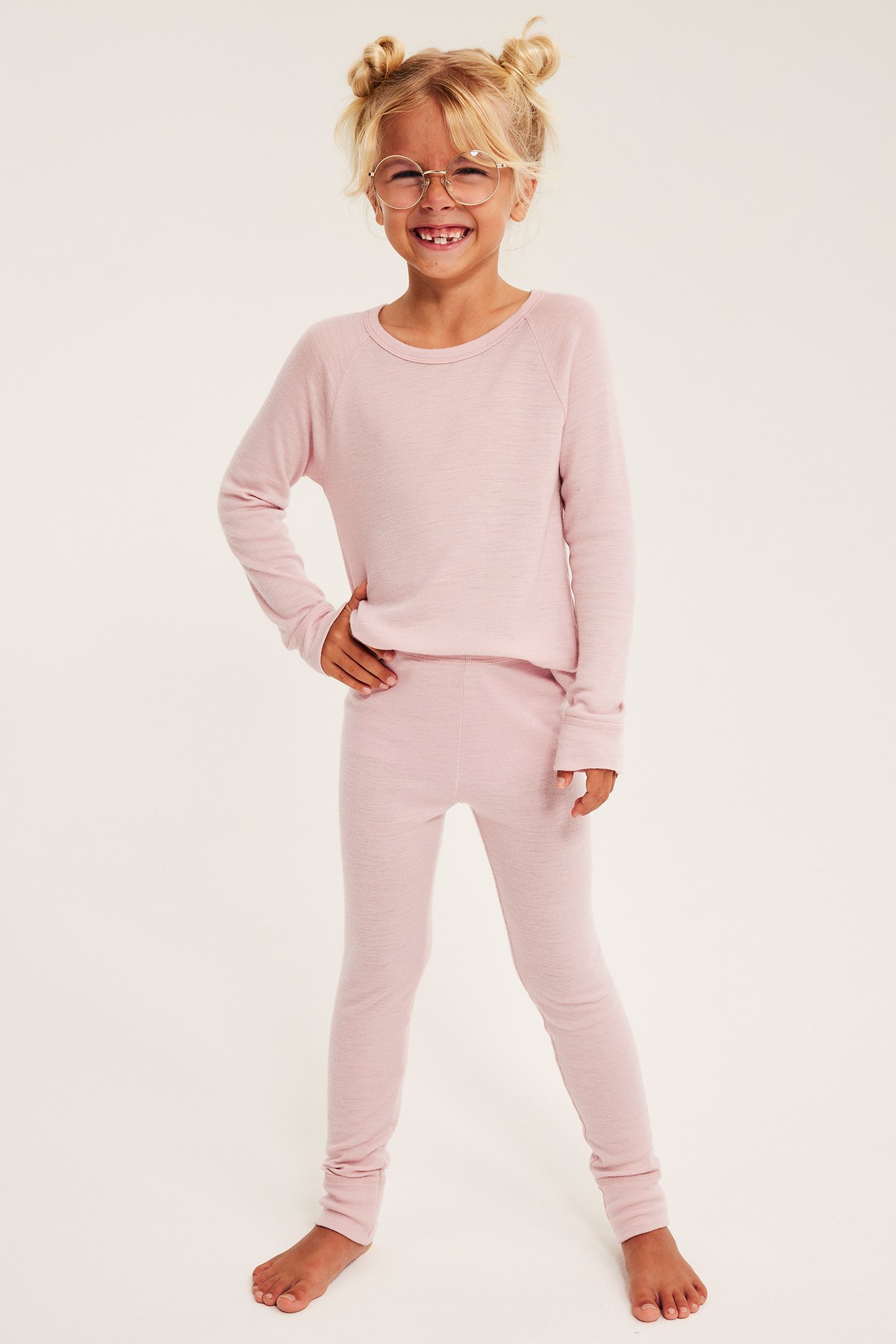Front, barn i rosa mykt strikket sett og runde briller.