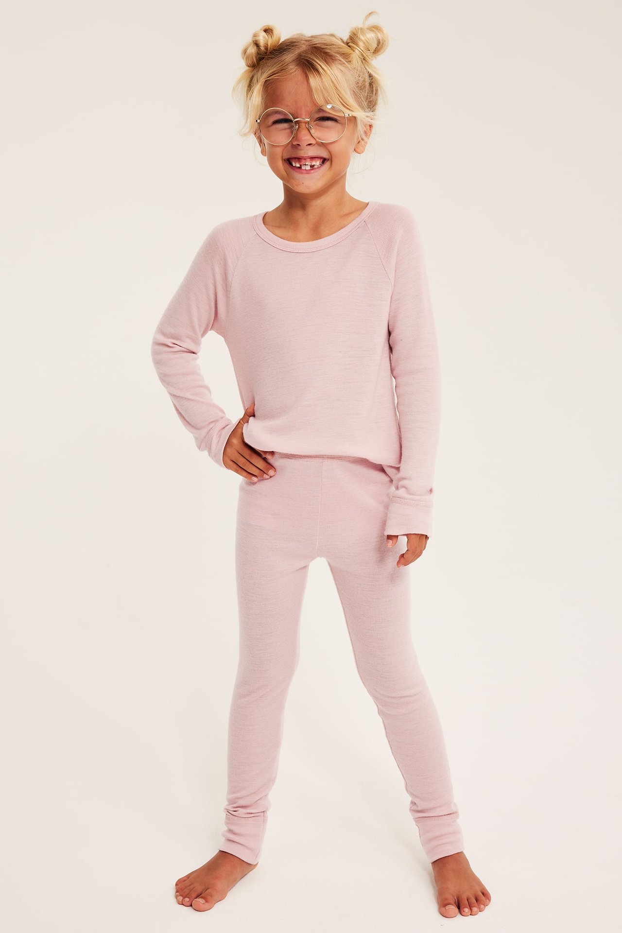 Front, barn i rosa mykt strikket sett og runde briller.