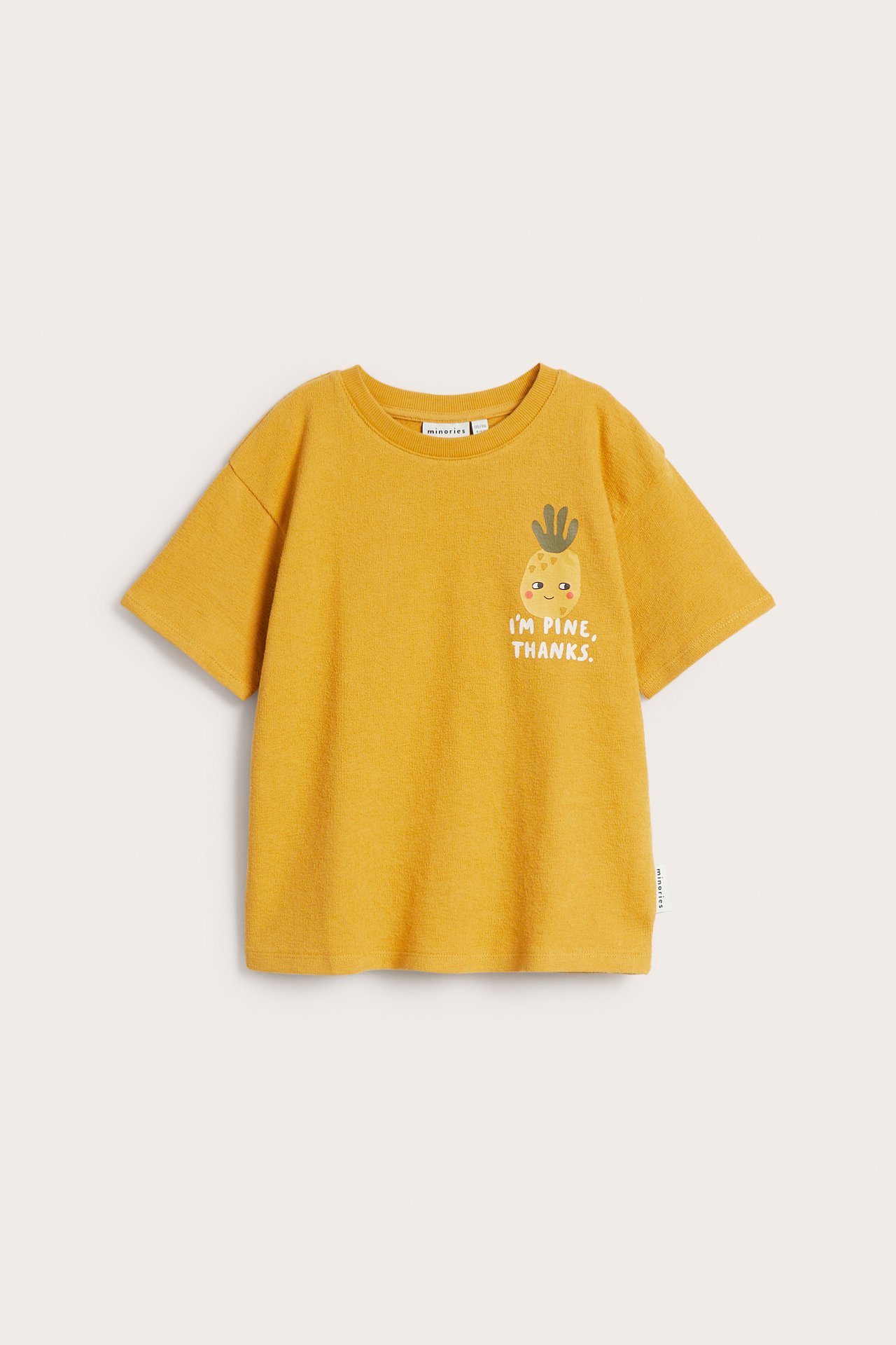 Widok z przodu: dziecięcy żółty bawełniany t-shirt z nadrukiem ananasa i tekstem.