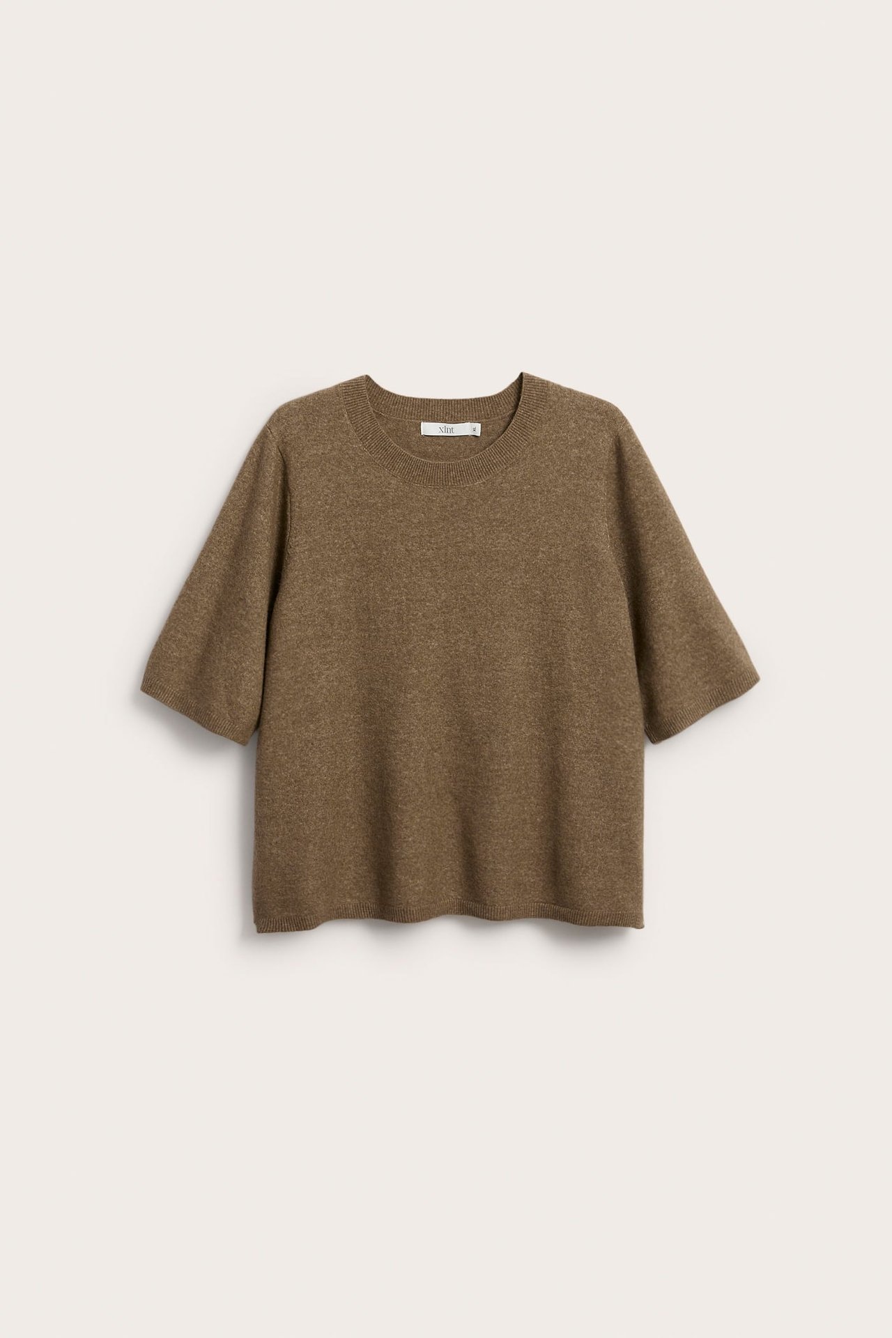 Edestä: meleerattu beige lyhythihainen neulepaita, pyöreä kaula-aukko, väljä istuvuus.