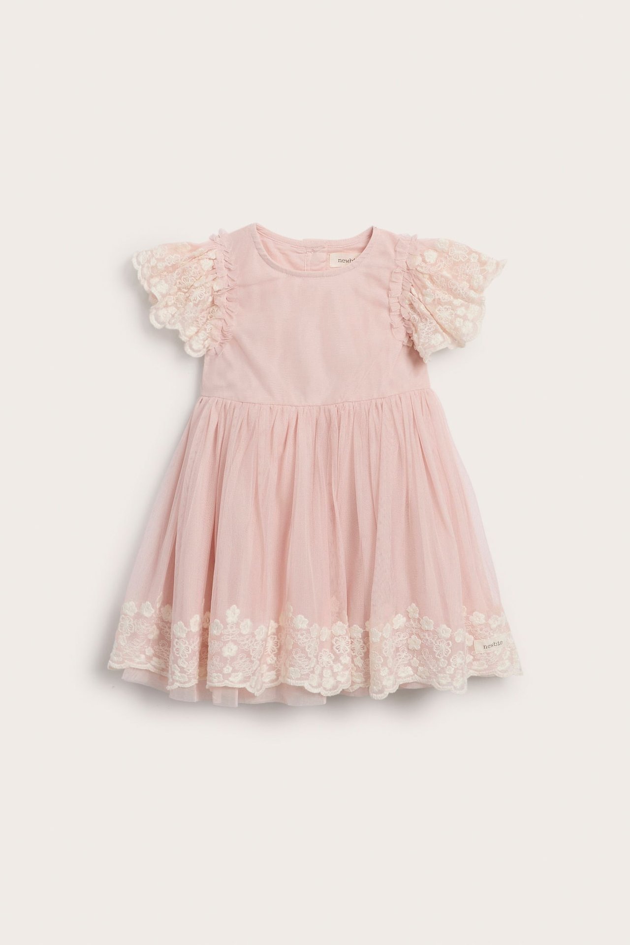 Frontvisning av en rosa babykjole med korte blondeermer og et blondedekorert tyllskjørt.