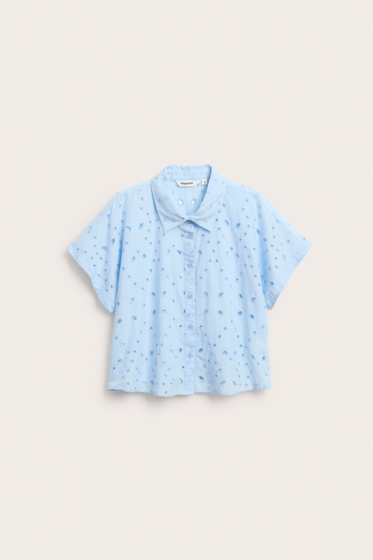 Edestä, vaaleansininen lyhythihainen puuvillapusero, jossa broderie anglaise ja edessä napitus.