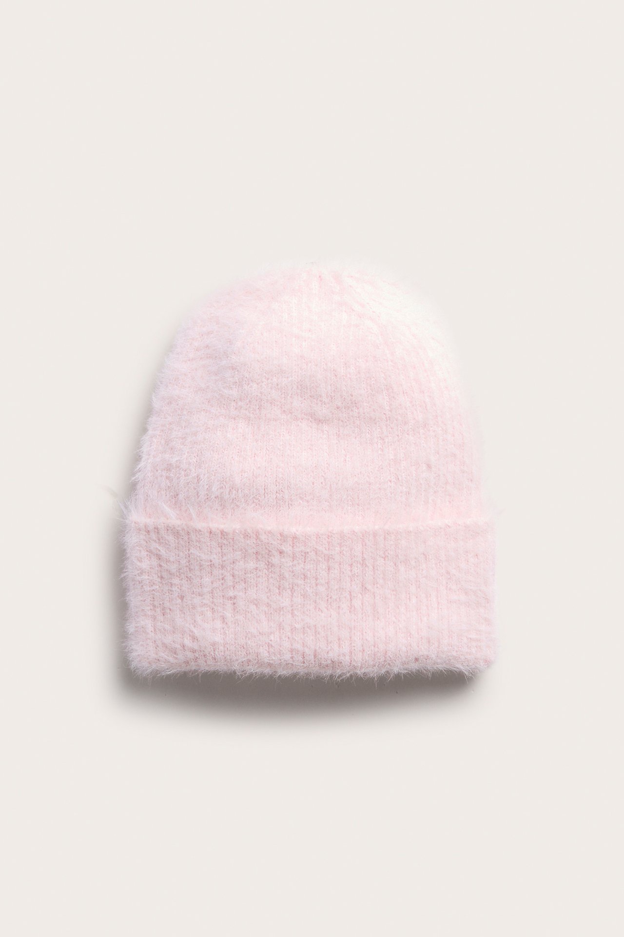 Fremfra, en lys rosa fluffy strikkelue.