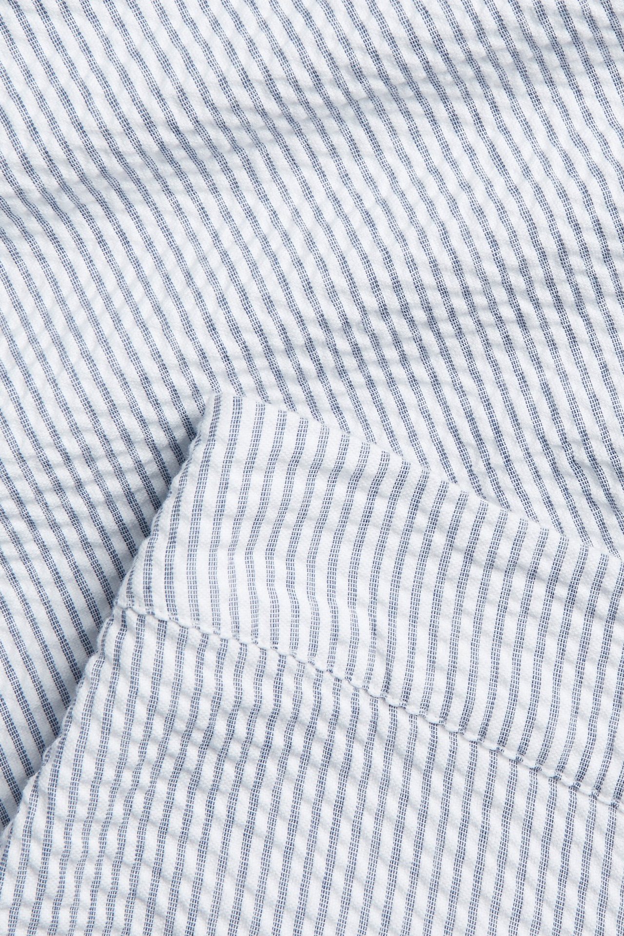 Närbild av blåvitrandigt bäckeböljatyg för vida byxor, vikt.