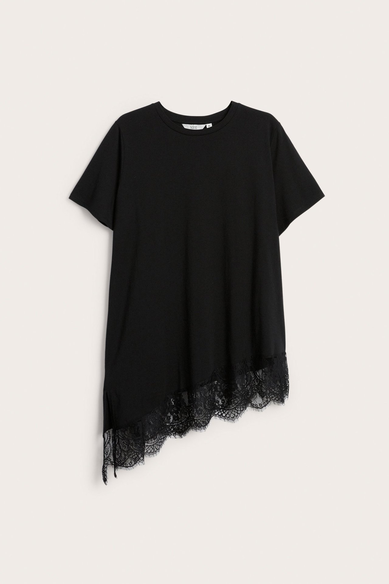 Edestä näkymä mustasta lyhythihaisesta topista, jossa epäsymmetrinen helma ja musta pitsikoriste.