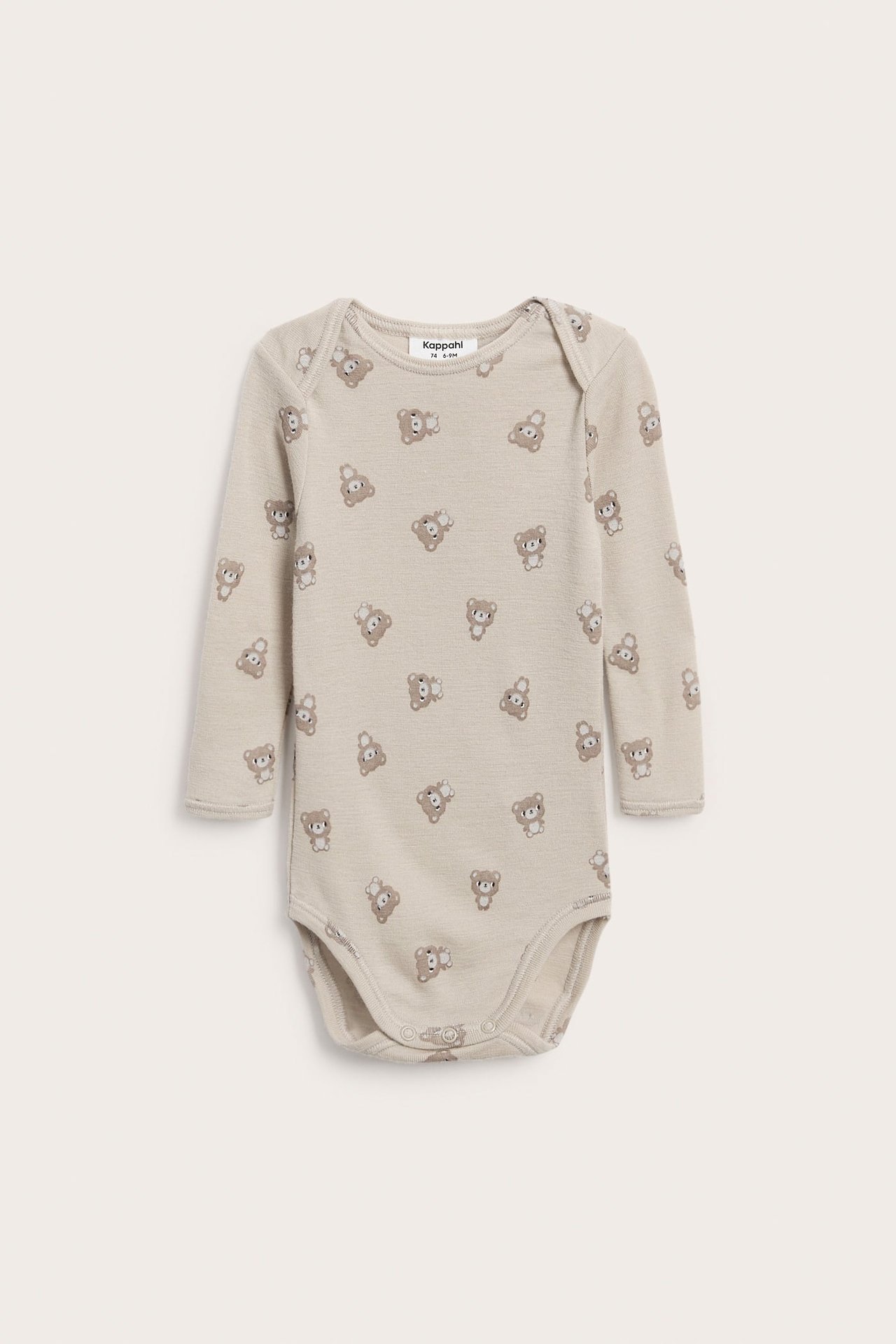 Edestä: Pitkähihainen beige vauvan body, jossa on ruskea nallekuvio ja nepparit.