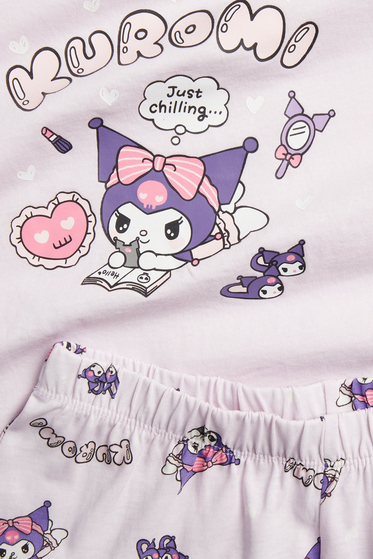 Zbliżenie na liliową, bawełnianą piżamę Kuromi z krótkim rękawem, z nadrukami postaci.