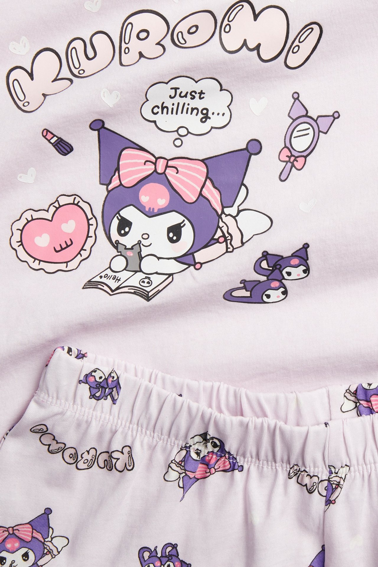 Zbliżenie na liliową, bawełnianą piżamę Kuromi z krótkim rękawem, z nadrukami postaci.