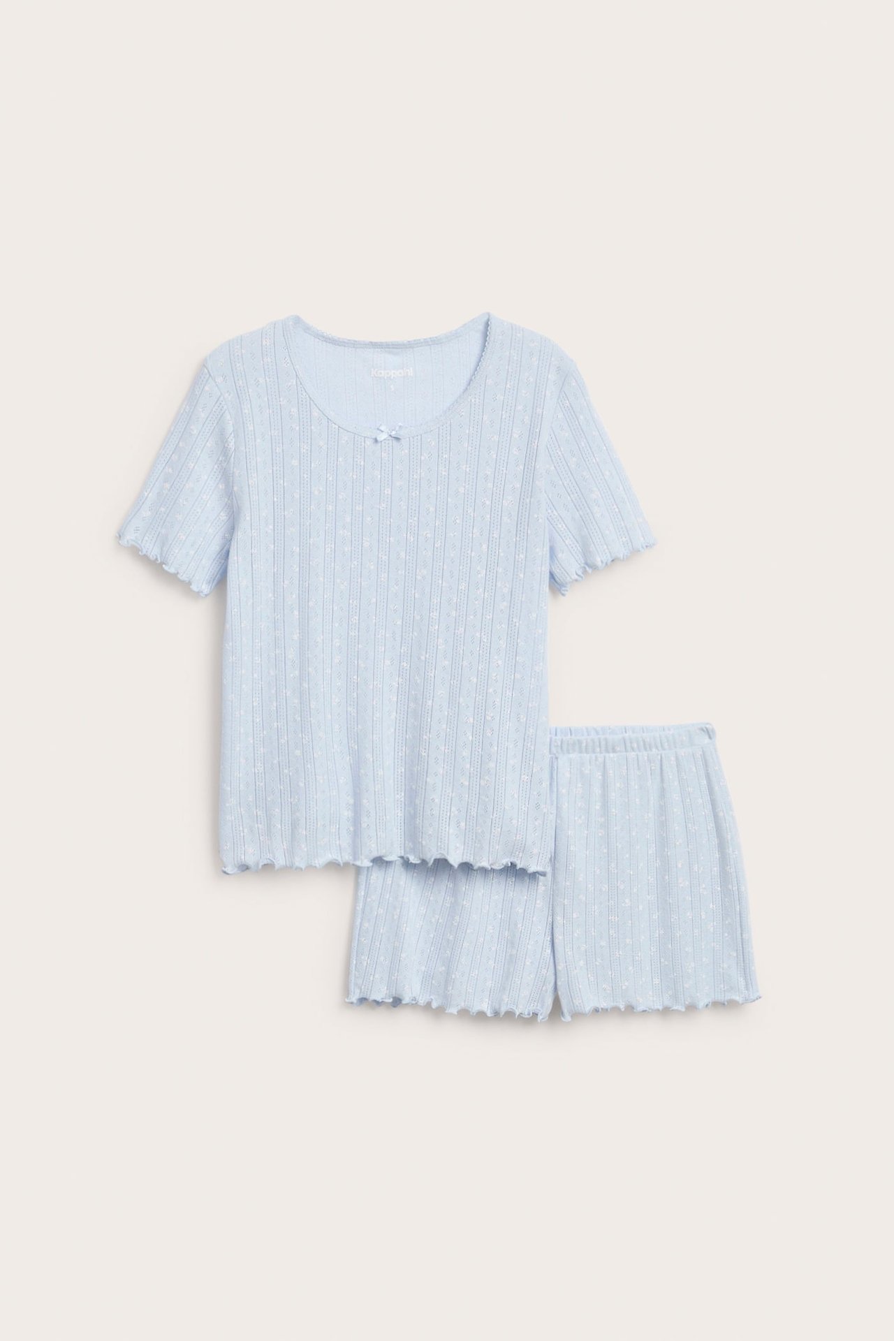 Vaaleansininen puuvillainen pointelle-pyjamassetti, lyhythihainen paita ja röyhelöreunaiset shortsit.