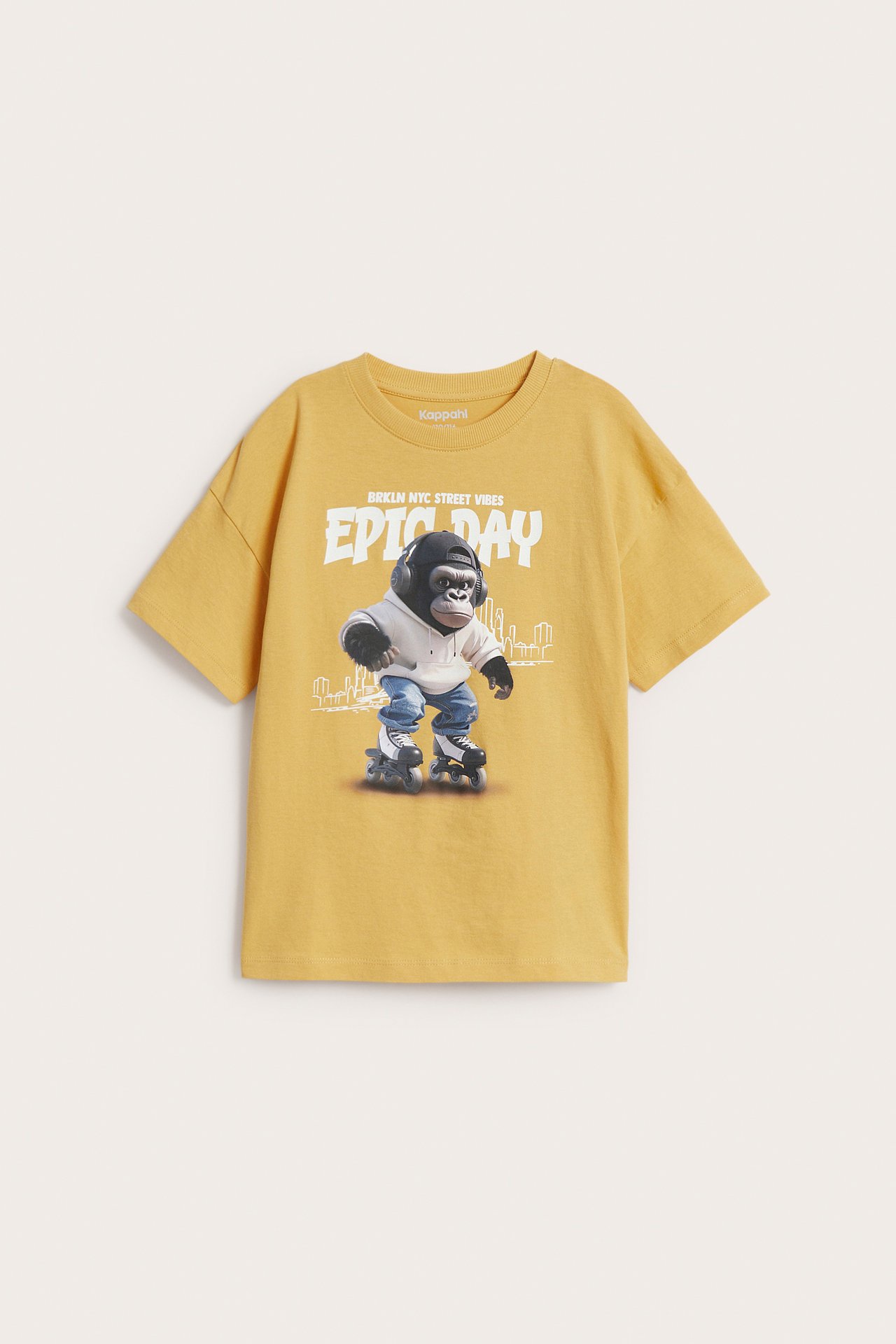 Widok z przodu: żółty bawełniany T-shirt oversize dla dzieci z gorylem w słuchawkach i na rolkach.