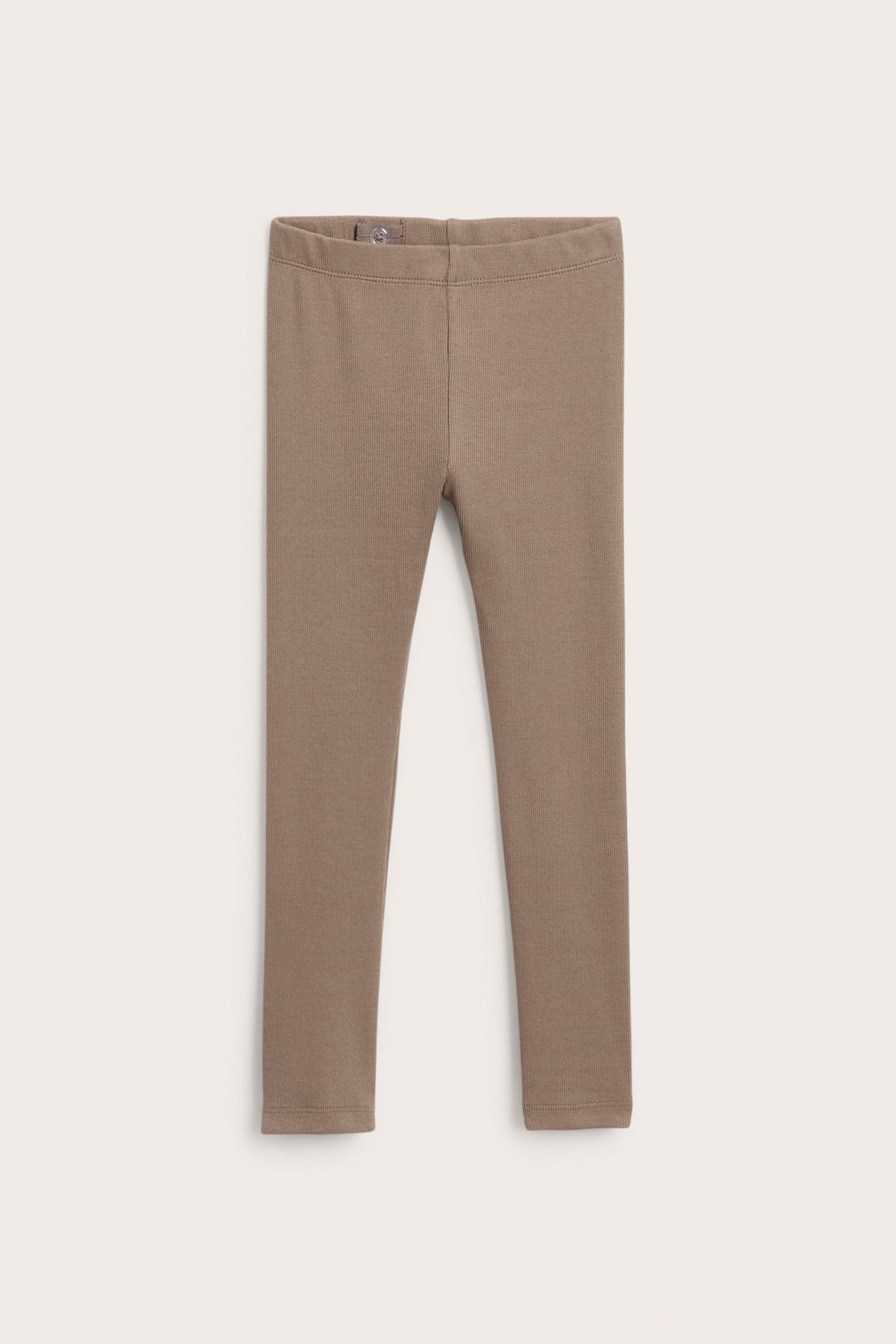Edestäpäin: vartalonmyötäiset ruskeat joustavat trikoolleggingsit joustovyötäröllä.