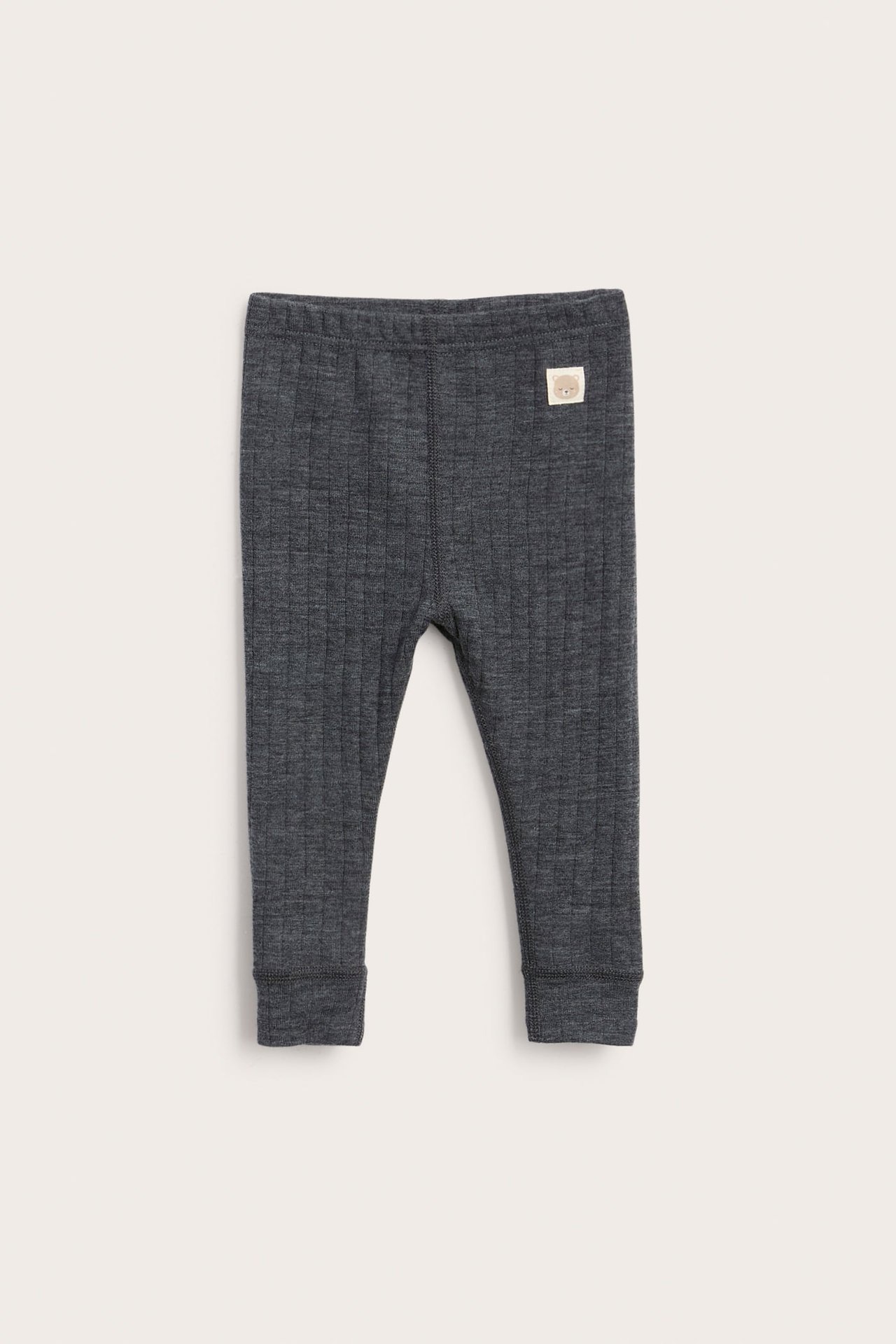 Frontvy av mörkgrå ribbade babyleggings med en liten björnapplikation.